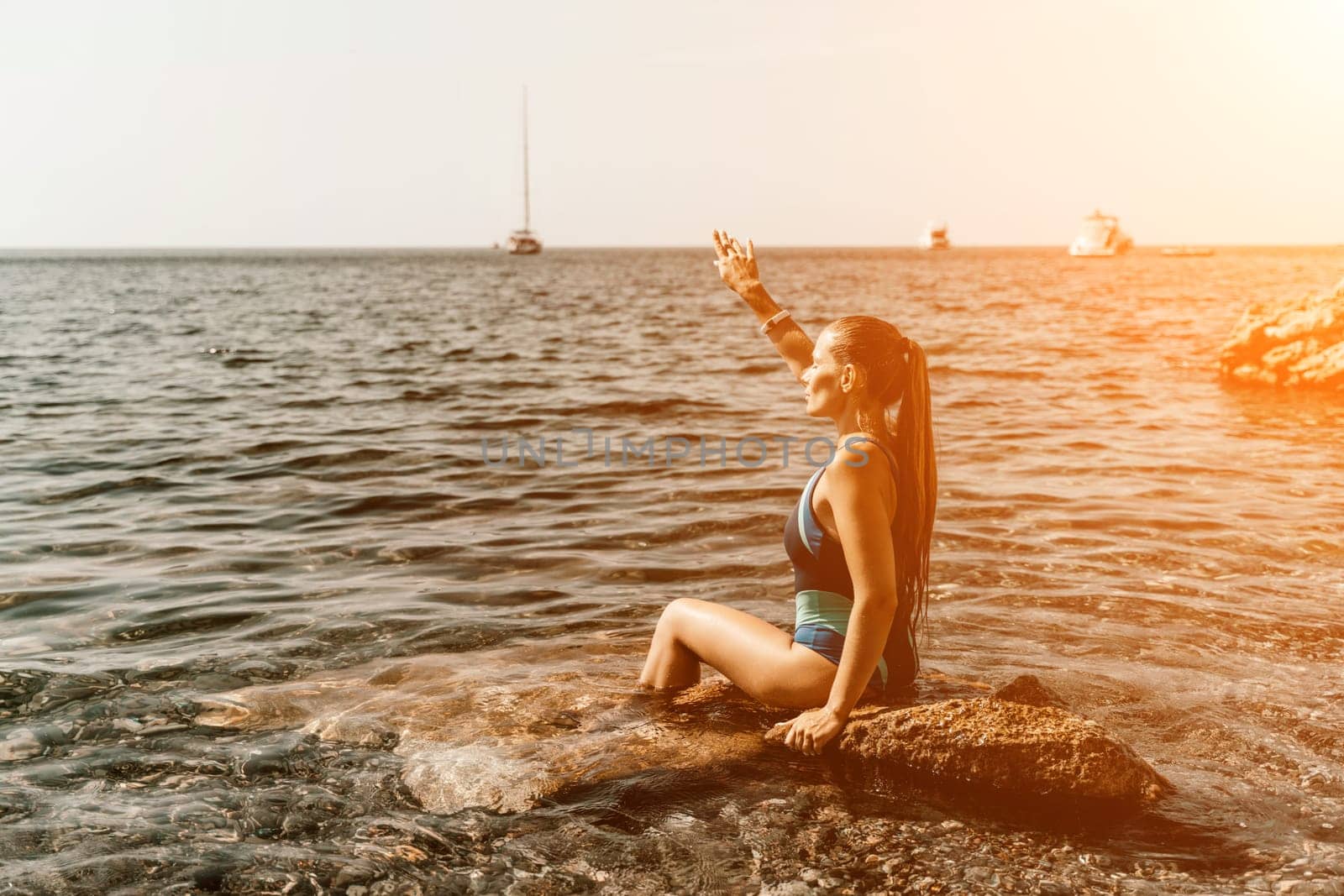 Woman travel summer sea. A happy tourist in a blue bikini enjoying the scenic view of the sea and volcanic mountains while taking pictures to capture the memories of her travel adventure. by Matiunina