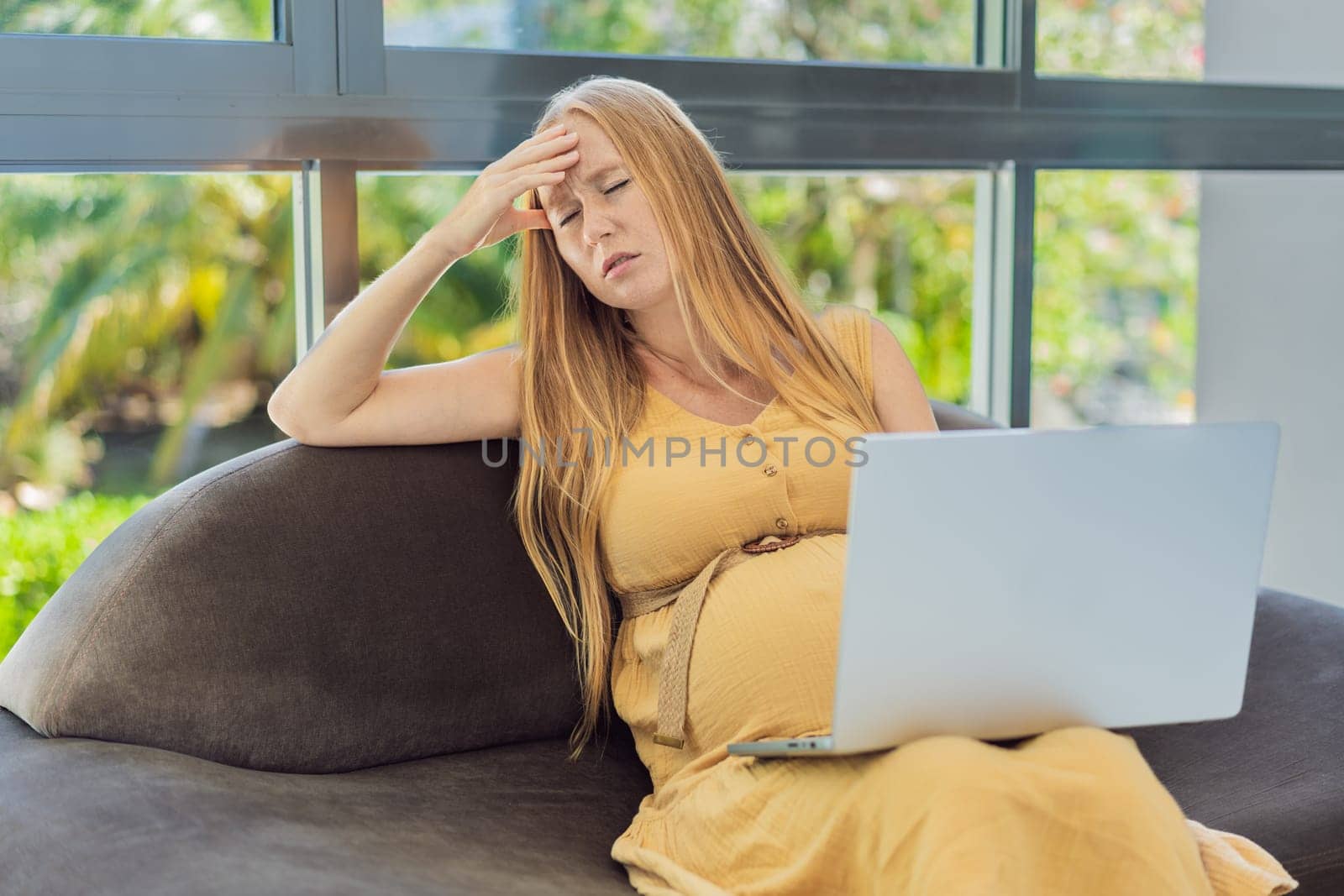 Weary pregnant woman, tired of working from home, navigates the challenges of balancing professional tasks with pregnancy demands by galitskaya