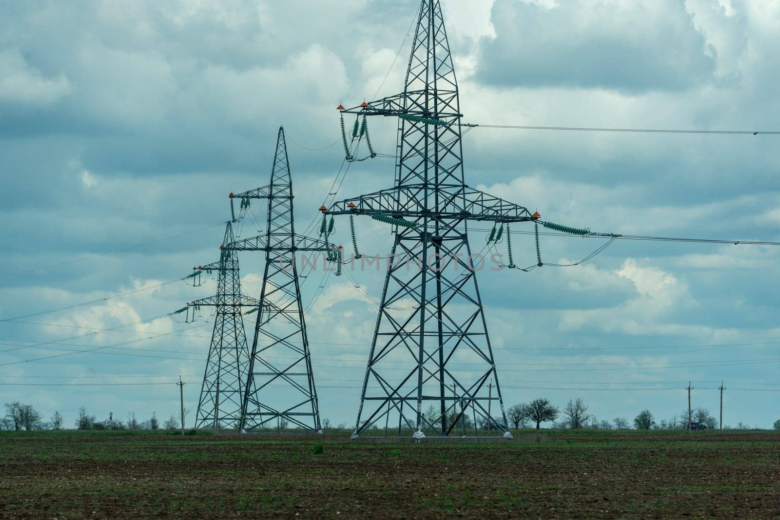 High voltage towers with sky background. Power line support with wires for electricity transmission. High voltage grid tower with wire cable at distribution station. Energy industry, energy saving.