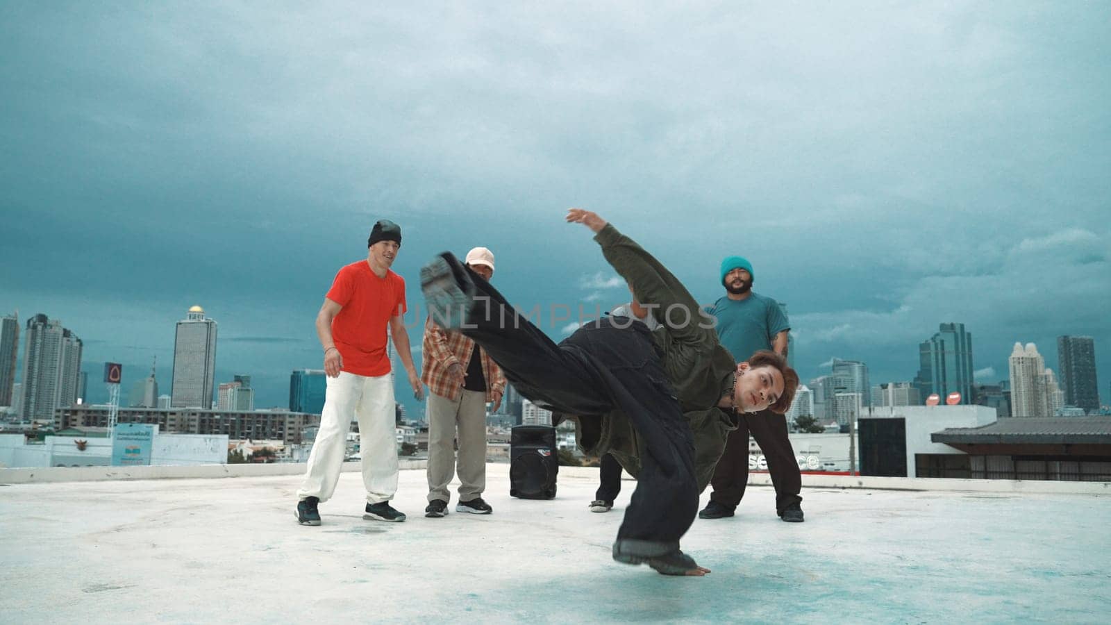 Hispanic hipster dancing surrounded by multicultural friend at city view with blue sky. Group of street dancer performing at rooftop. Active, fun, happy atmosphere. Outdoor sport 2024. Endeavor.