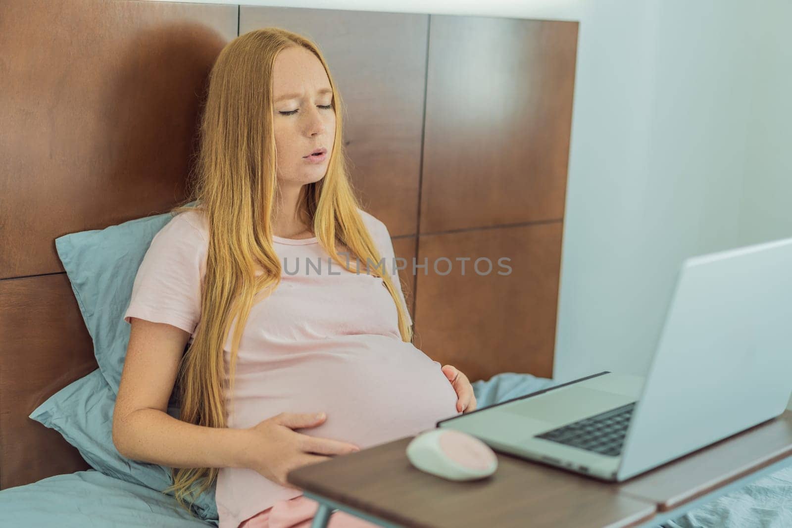 Weary pregnant woman, tired of working from home, navigates the challenges of balancing professional tasks with pregnancy demands by galitskaya