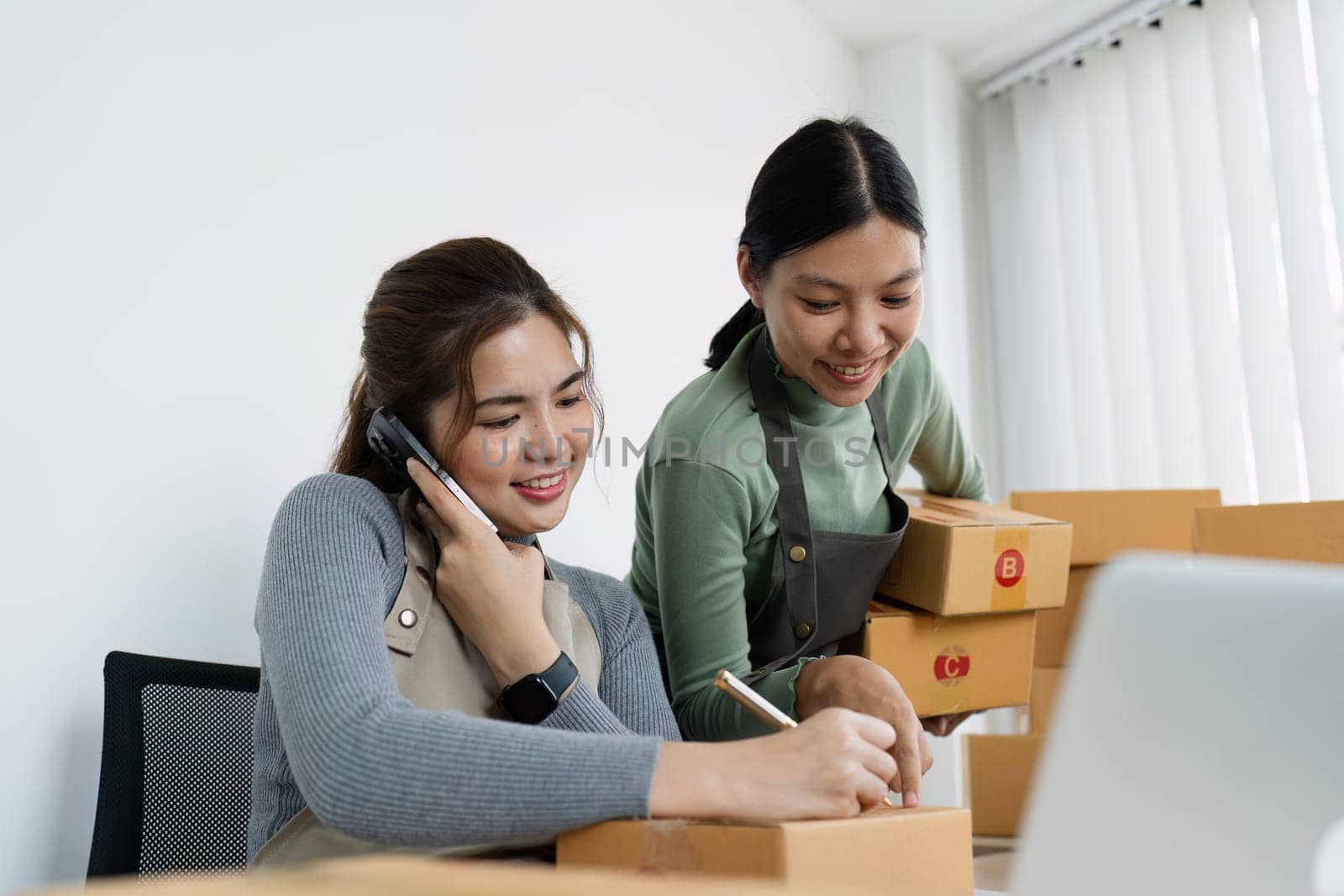 Asian woman write parcel box to prepare for delivery to customer. e-business concept.