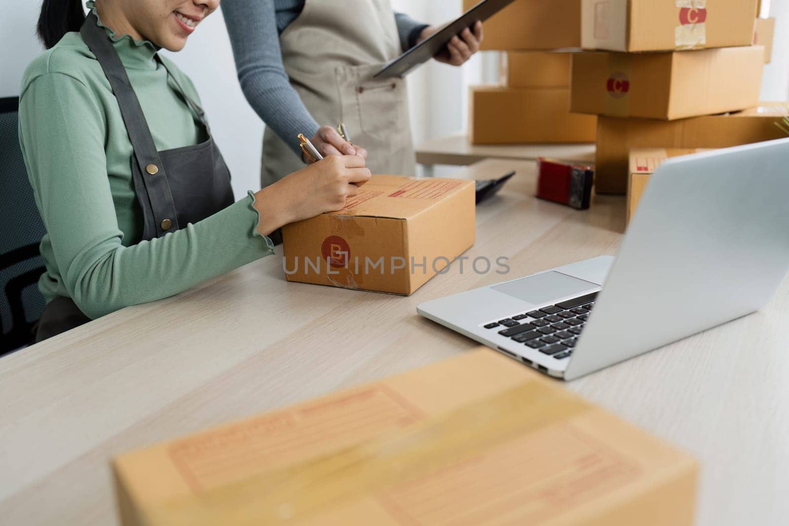 Asian woman write parcel box to prepare for delivery to customer. e-business concept.