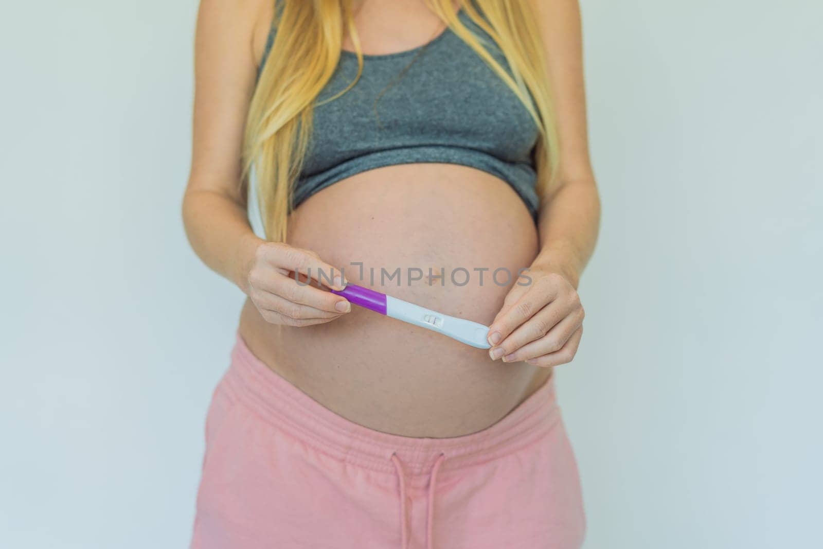 Joyful pregnant woman shares the exciting news, proudly displaying her positive pregnancy test and a heartwarming ultrasound photo by galitskaya