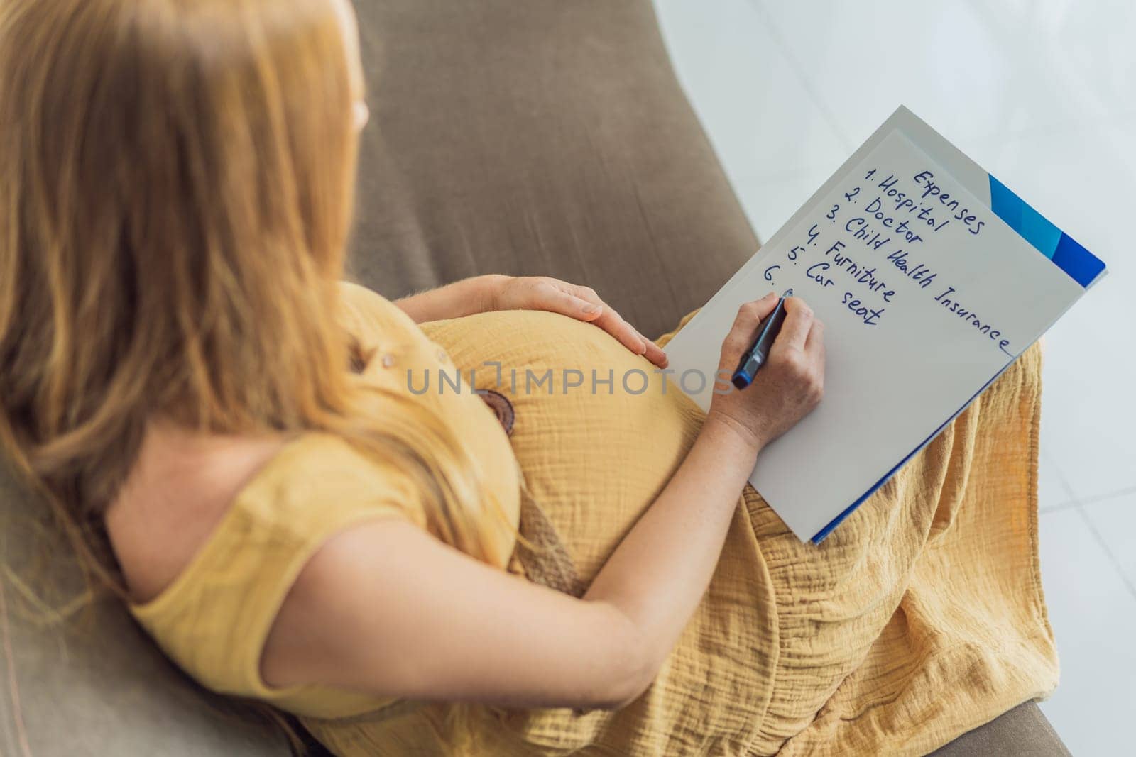 Expectant woman diligently compiles a list of childbirth costs, planning and organizing financial considerations for the upcoming delivery.