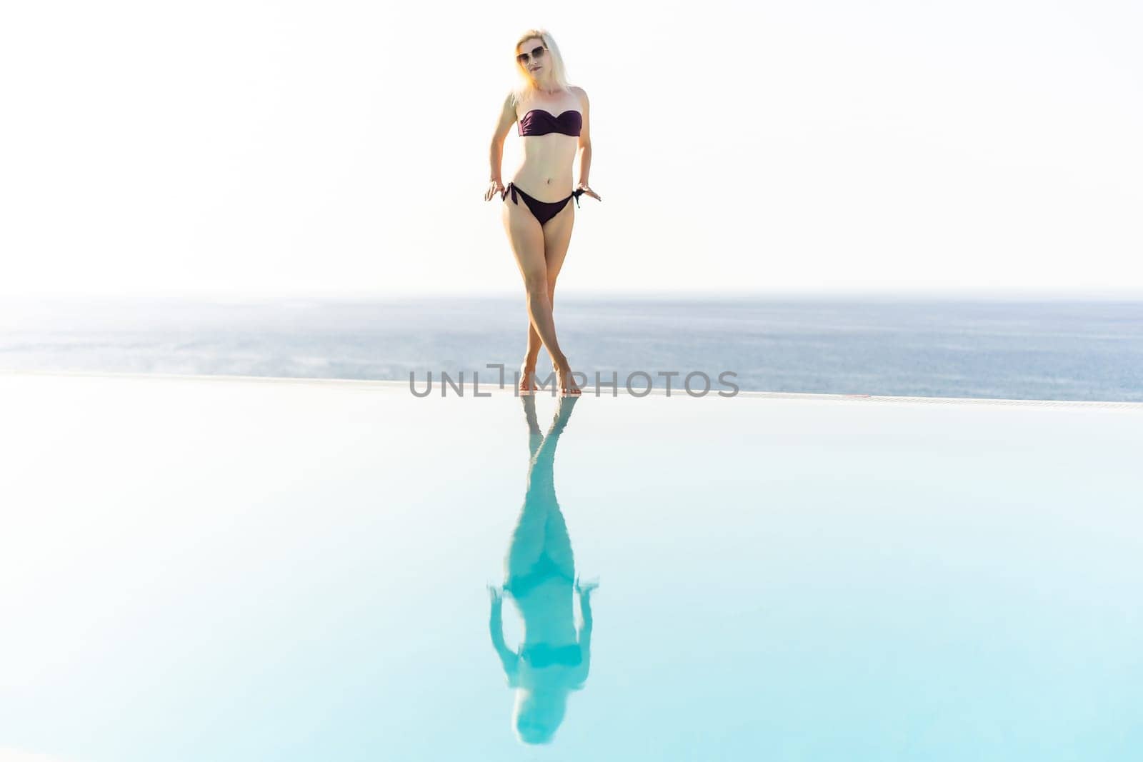 Summer in the city. Happy young woman near swimming pool.