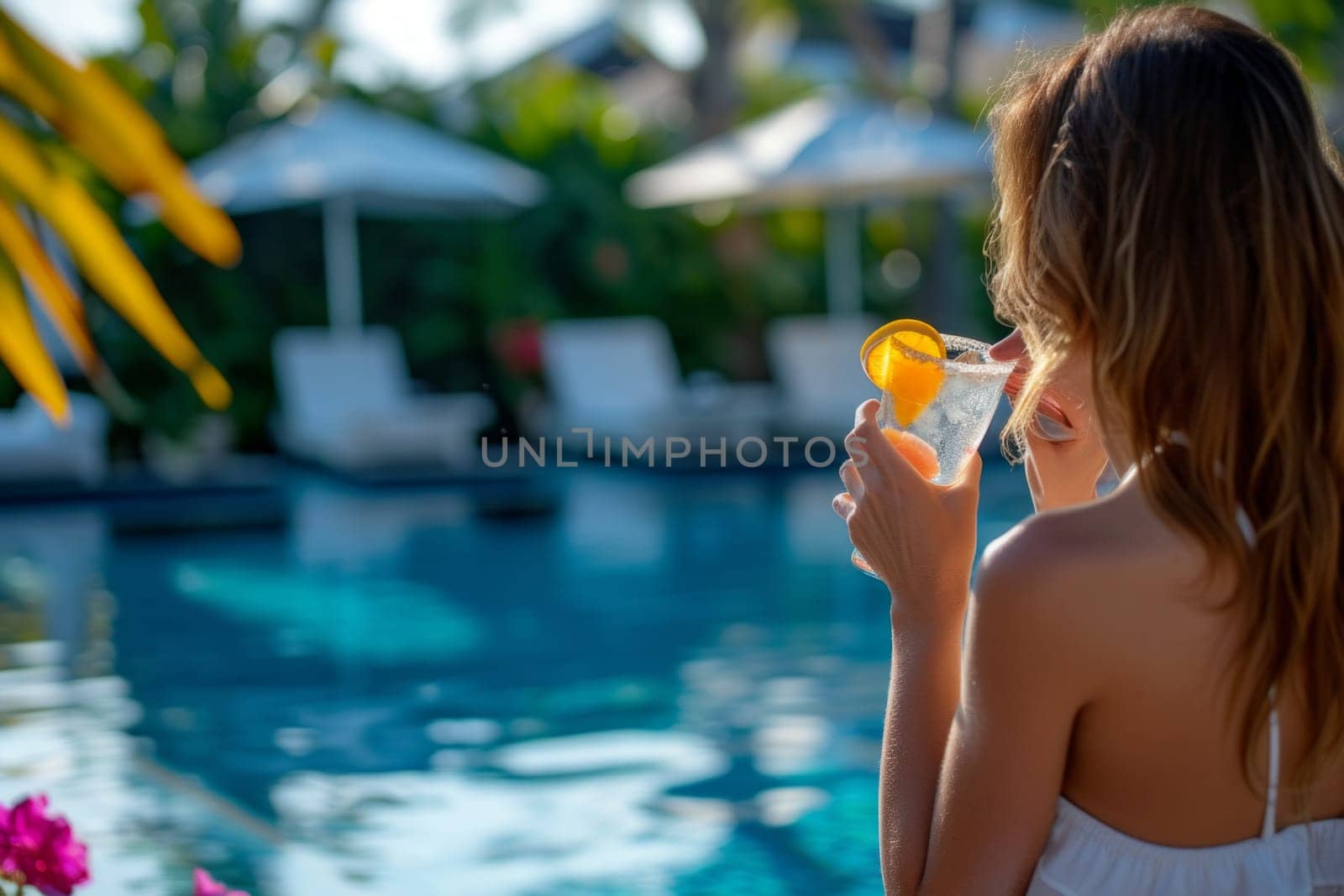 Close up view of young relaxed woman in a hotel pool enjoying a cocktail drink.
