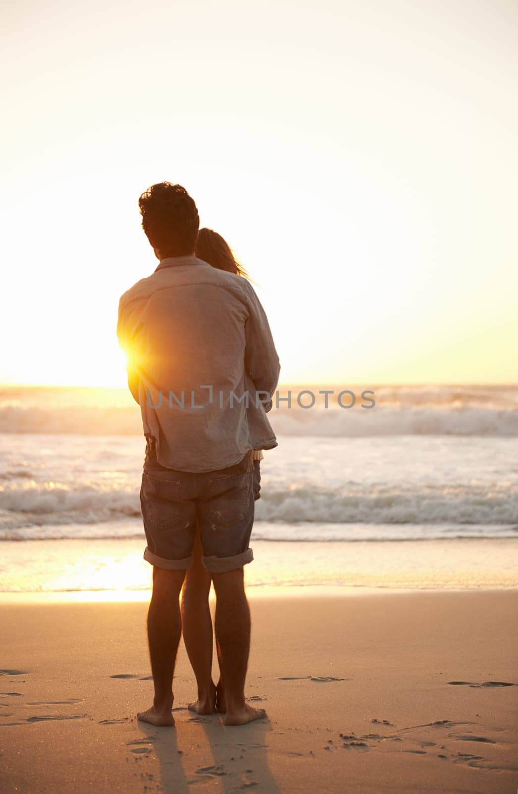 Man, woman and beach hug at sunset for summer travel or adventure, bonding or marriage. Happy couple, embrace and sea water for dating tourism or back view for nature vacation, environment or holiday by YuriArcurs