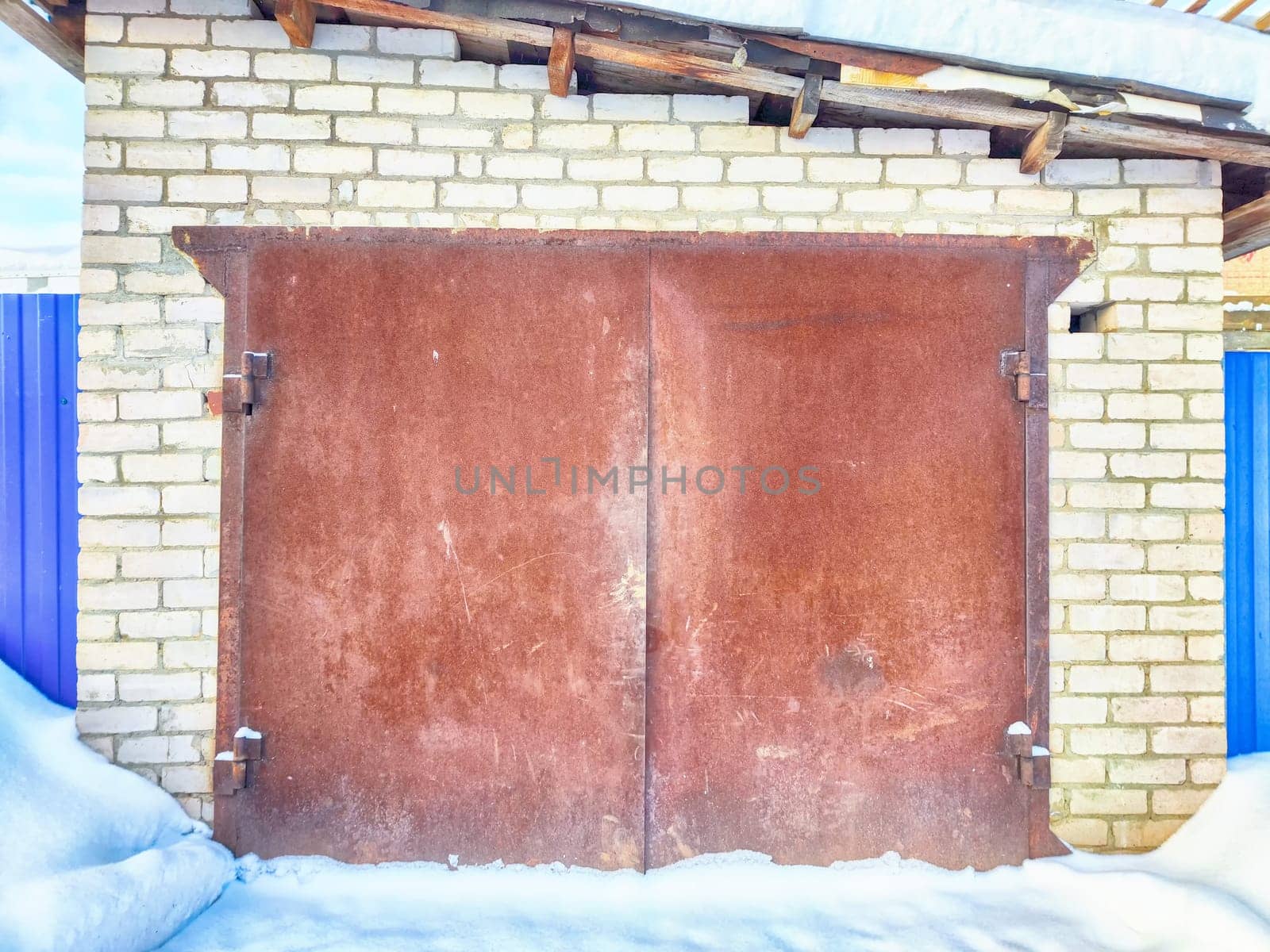 The metal gate of the old brick garage. Location, background and texture