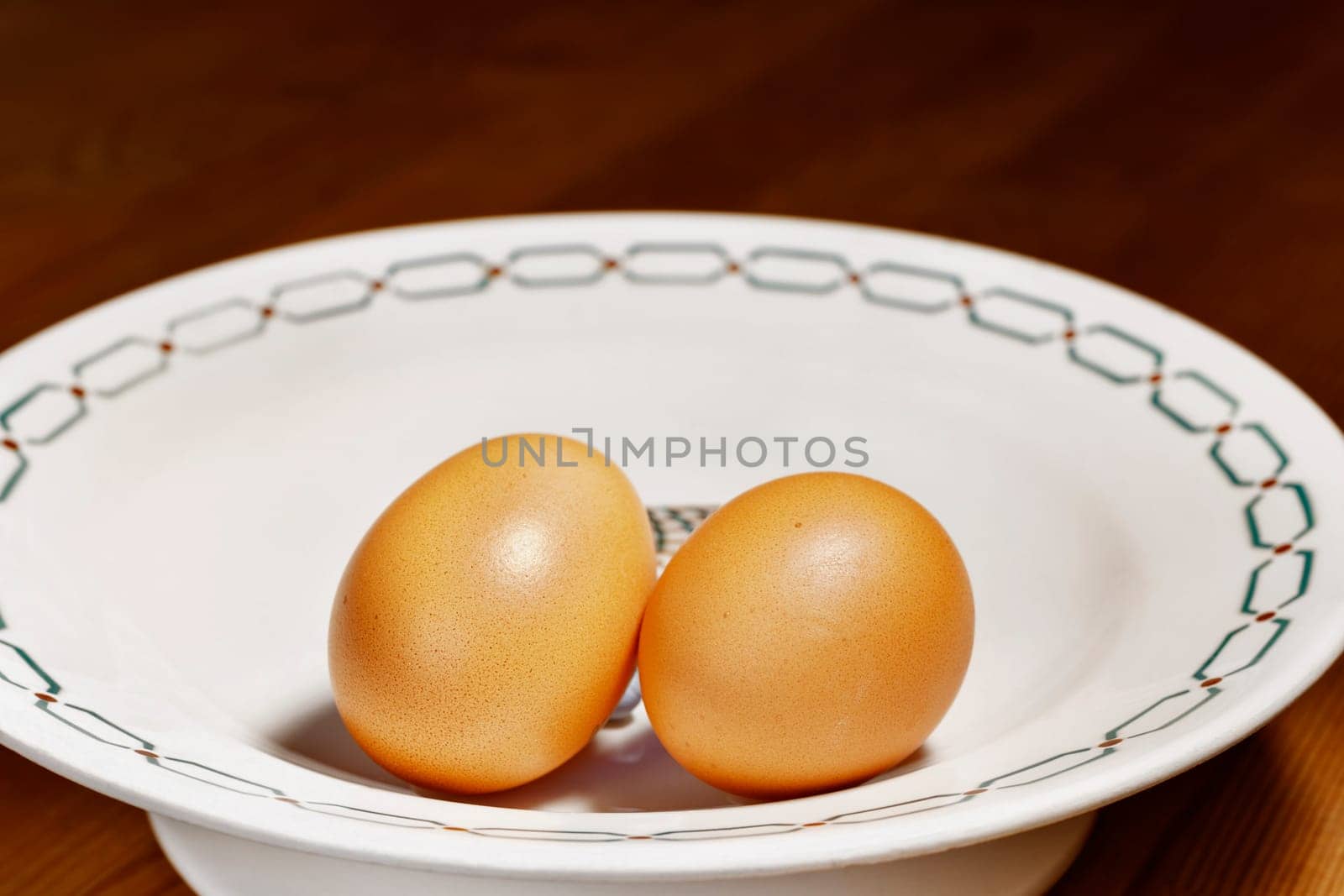 Detail of hand putting chicken eggs in white bowl , preparing food , 