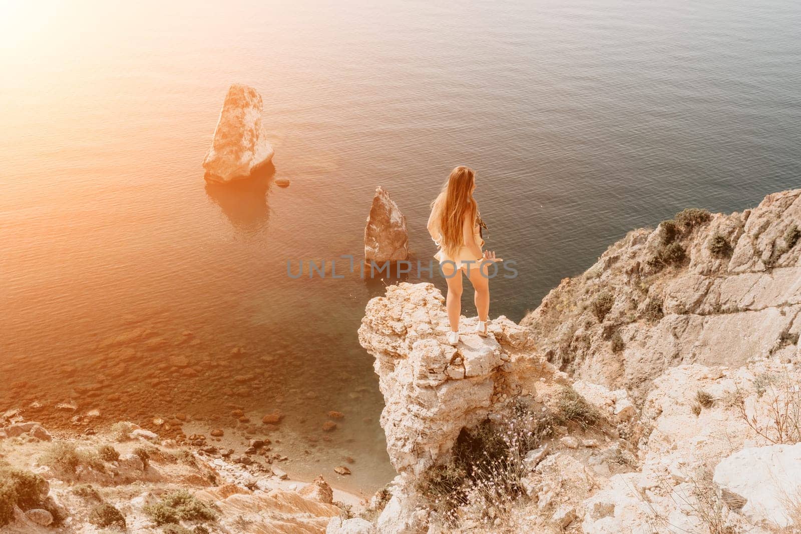 Woman travel sea. Happy tourist enjoy taking picture outdoors for memories. Woman traveler looks at the edge of the cliff on the sea bay of mountains, sharing travel adventure journey by panophotograph