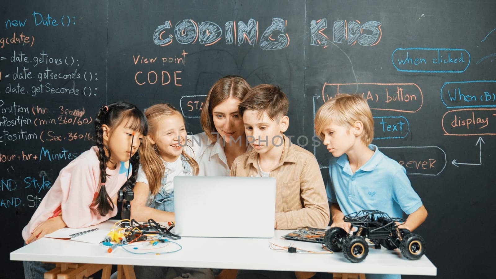 Diverse student writing engineering code while boy fixing mother board. Teacher giving advice and teaching about robotic system while learner studying and learning about coding prompt. Erudition.