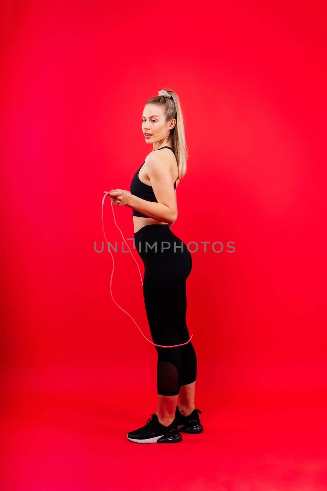 Happy fit woman over studio background. Smiling female fitness workout. Healthy lifestyle concept. by Zelenin