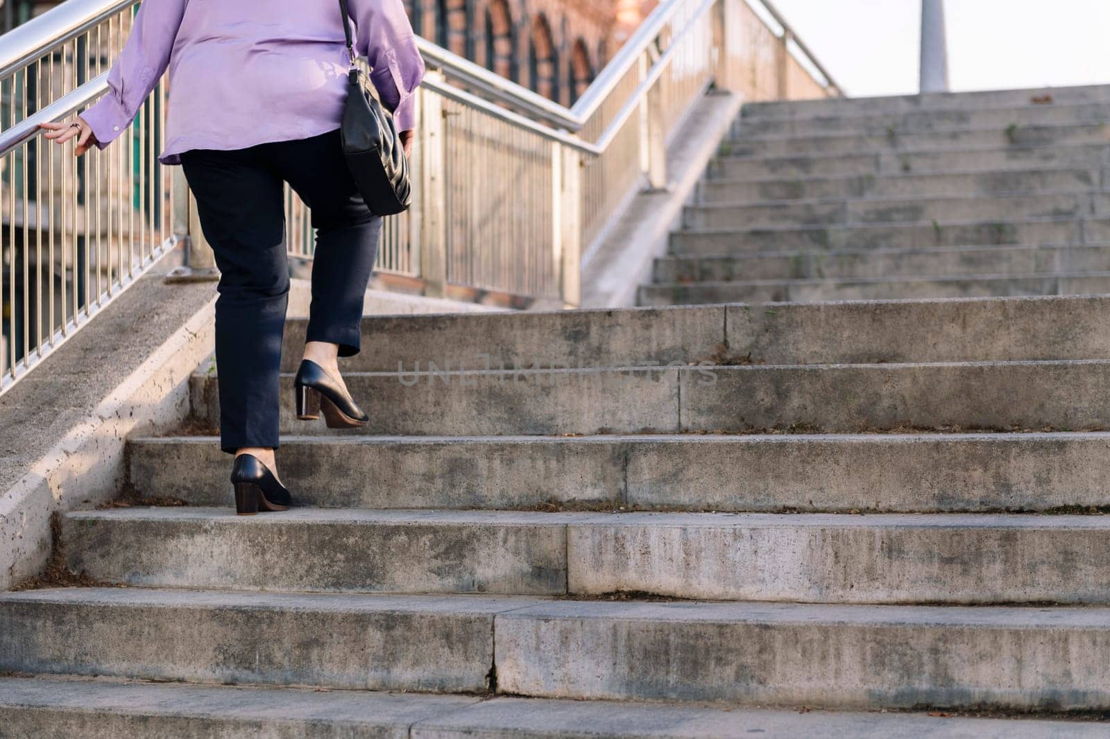 legs of senior woman walking up stairs at city by raulmelldo