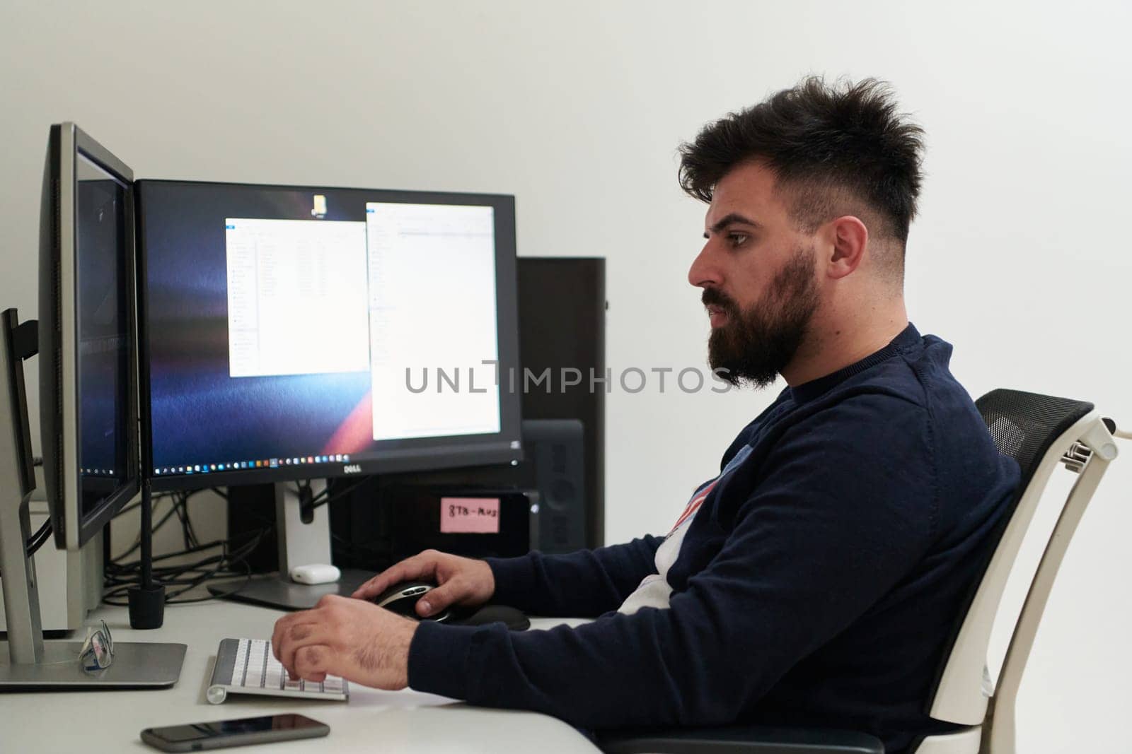 professional video editor enhancing digital footage using specialized software. Expert videographer in home office workspace editing on dual screen workstation computer desktop workplace