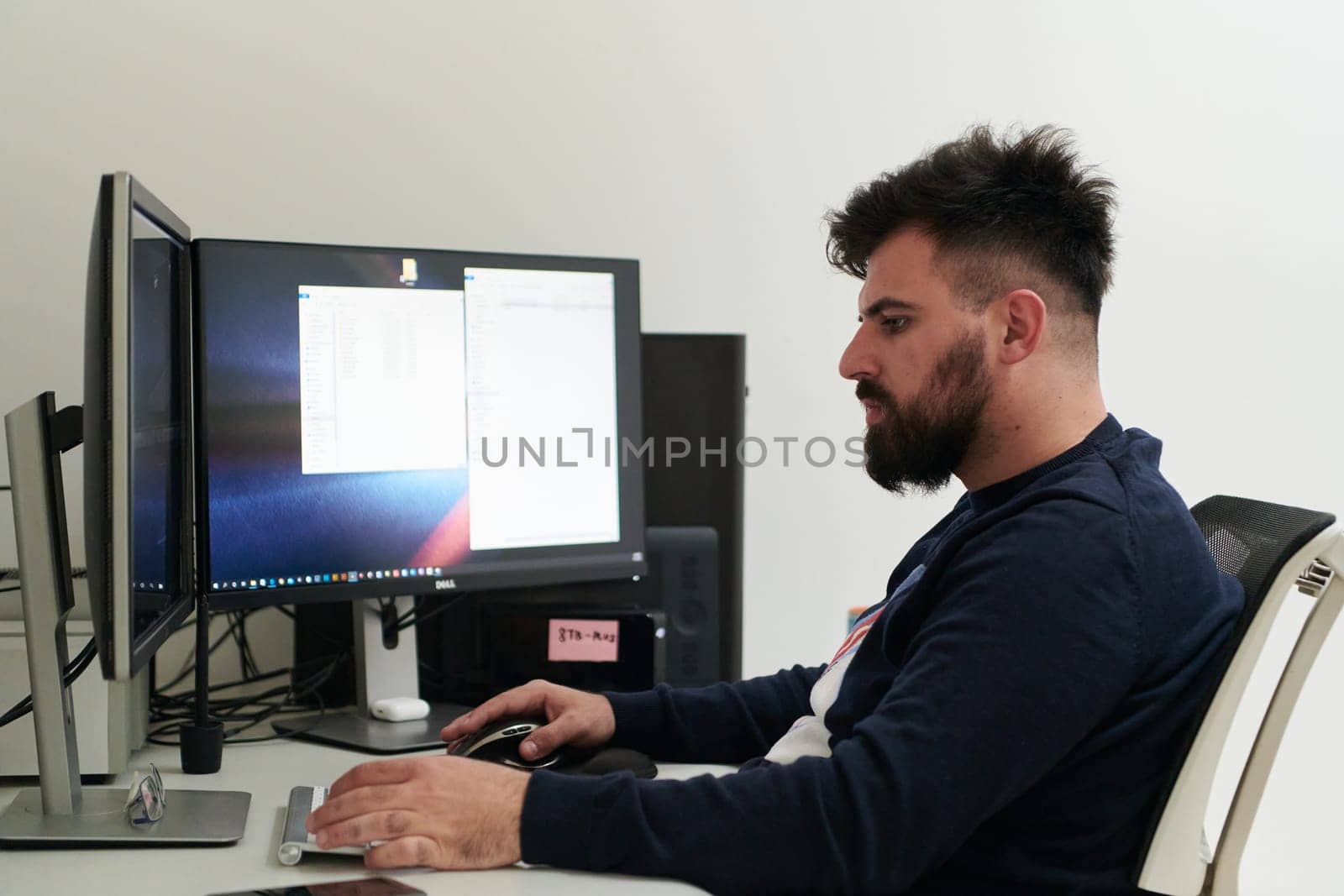 professional video editor enhancing digital footage using specialized software. Expert videographer in home office workspace editing on dual screen workstation computer desktop workplace