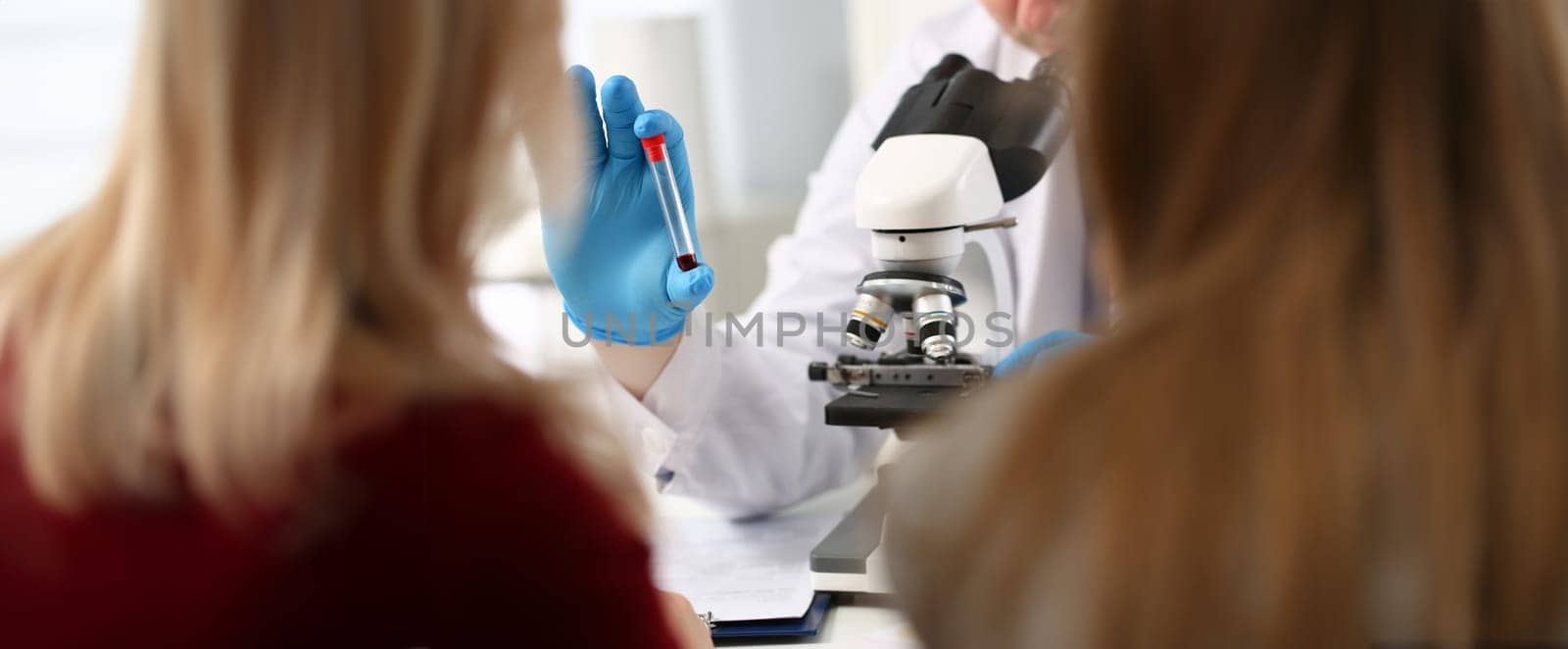 Doctor patient blood sample front microscope. Test results for coronavirus. Virological laboratory. Incubation period infectious diseases. Women are waiting for blood test. Blood sampling