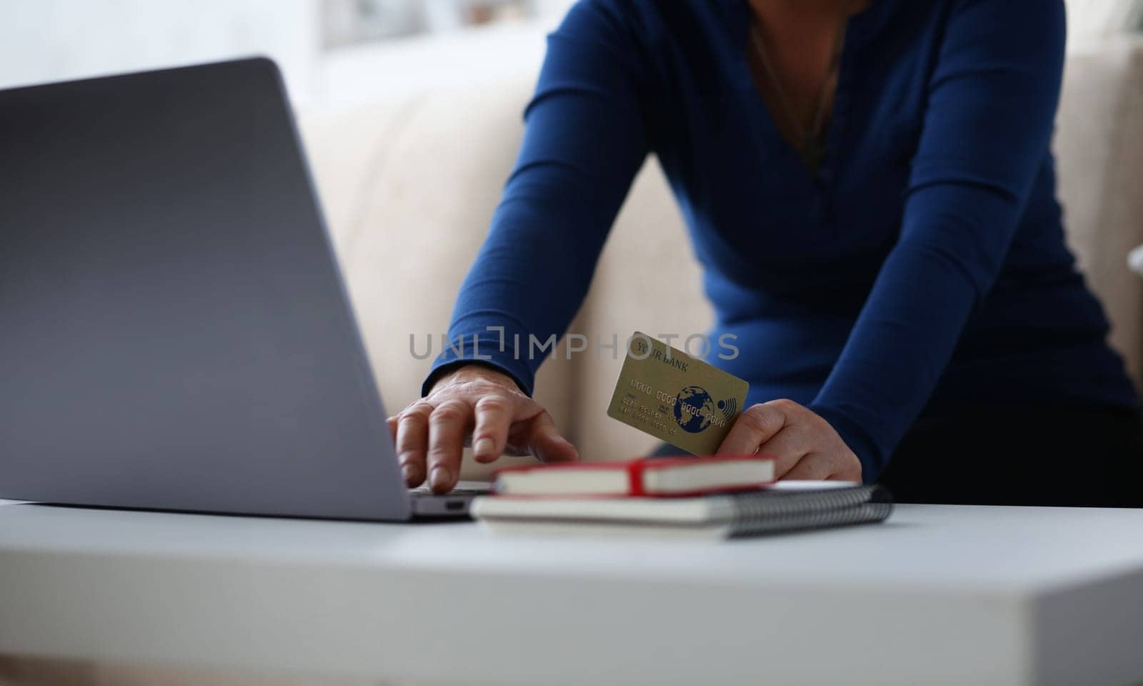 Woman enters credit card details in browser laptop. Pay loan during pandemic. Control all operations on account and check balance during period self-isolation. Buy and sell currency in online banking