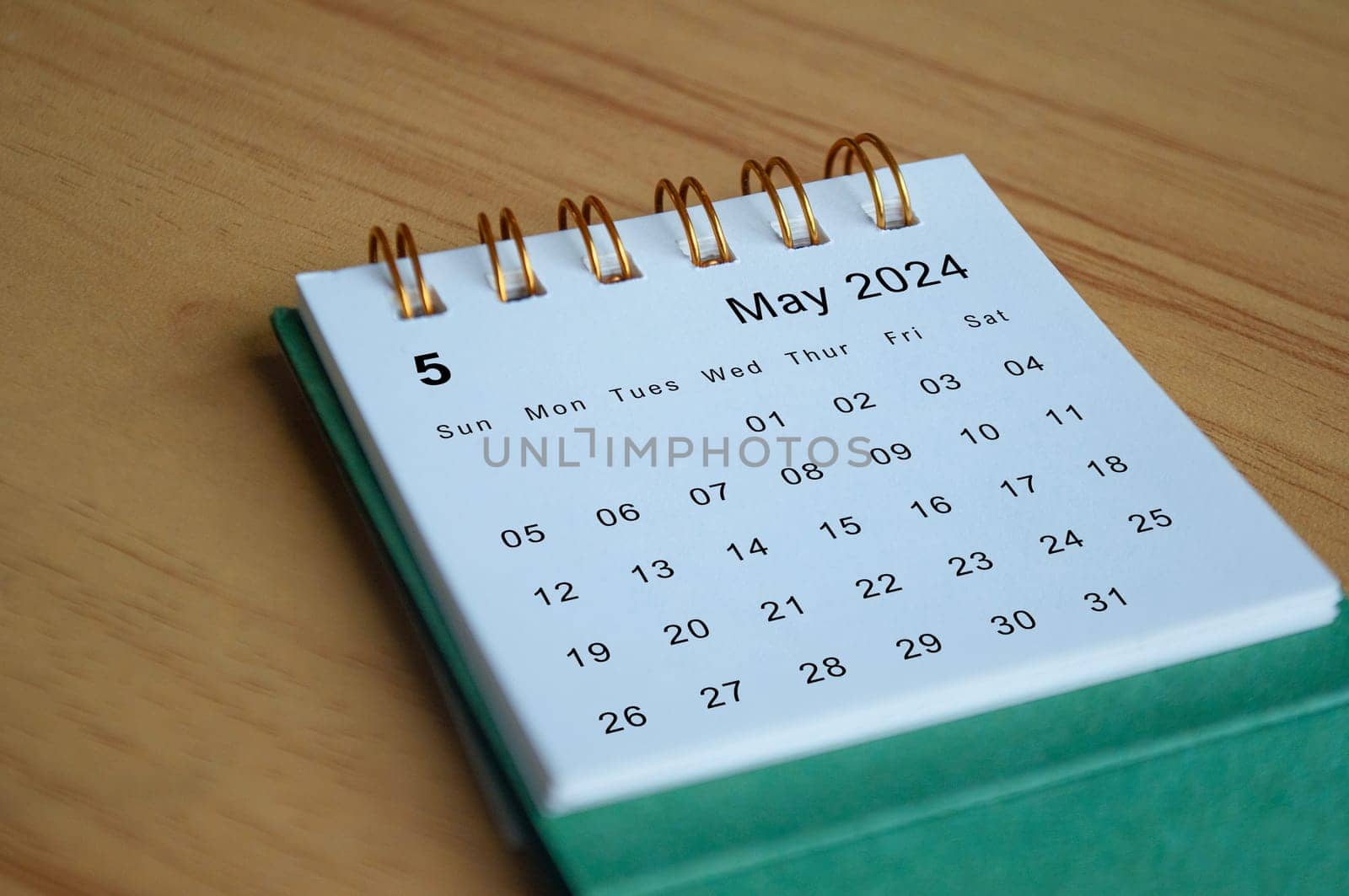 Close up side view of May 2024 calendar on wooden desk. Calendar concept.