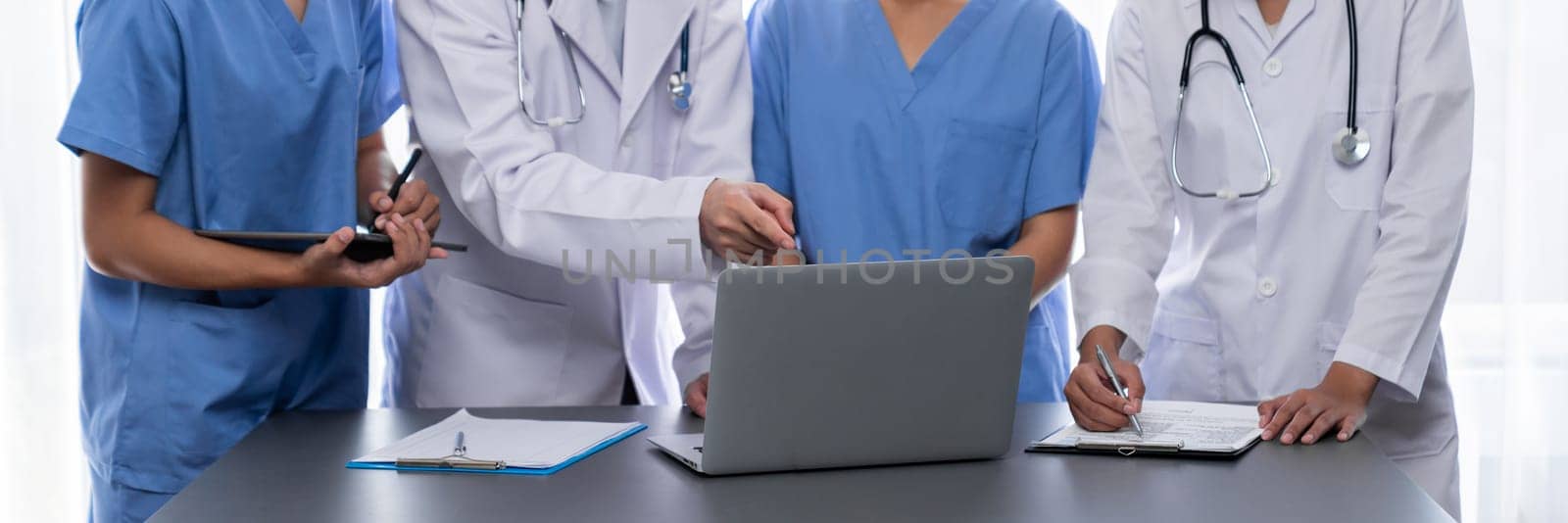 Doctor and nurse in medical meeting discussing strategic medical treatment plan together with report and laptop. Medical school workshop training concept in panoramic banner. Neoteric