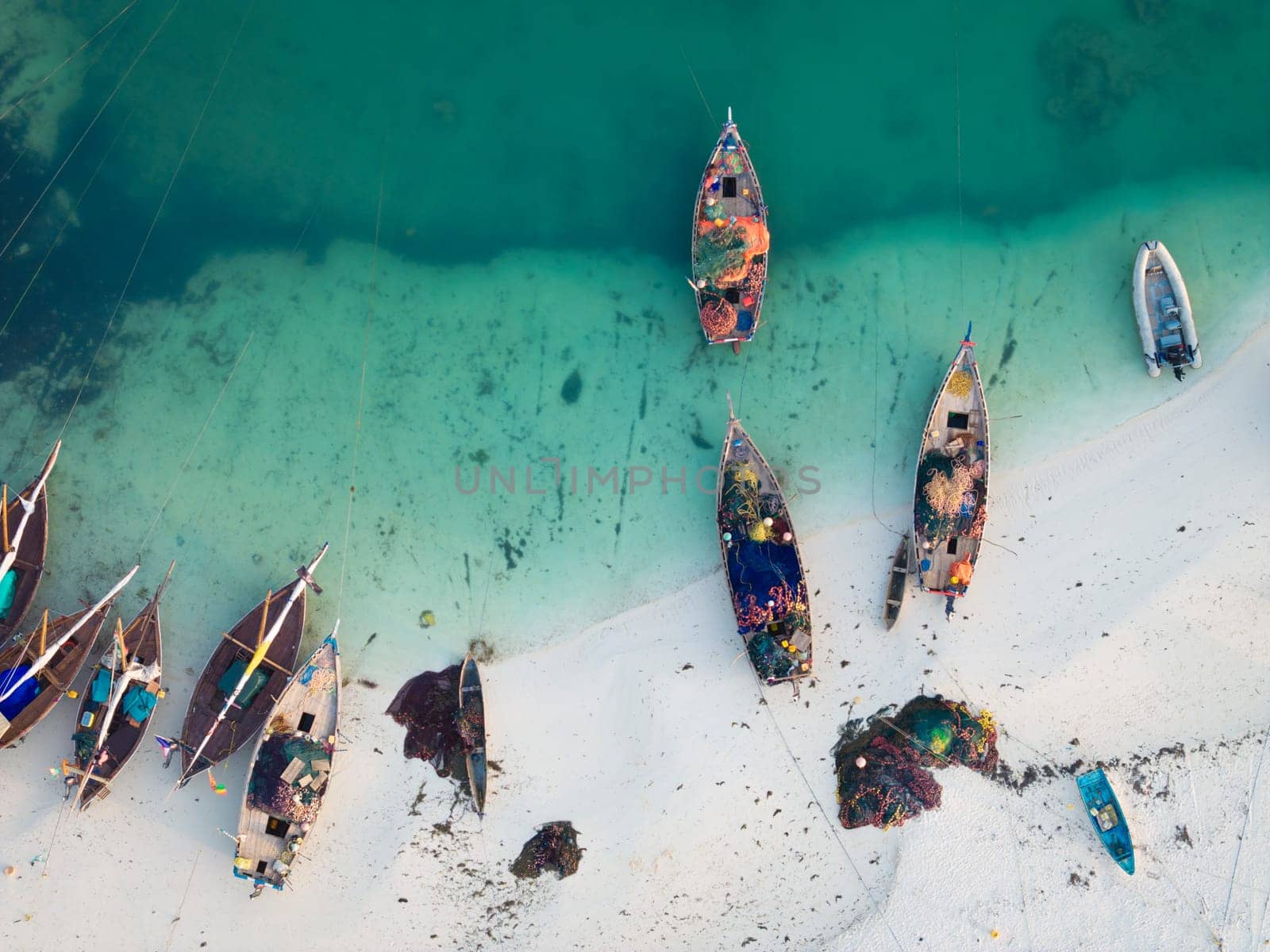 Drone shot of wooden fisherman boats and white sandy beach by Robertobinetti70