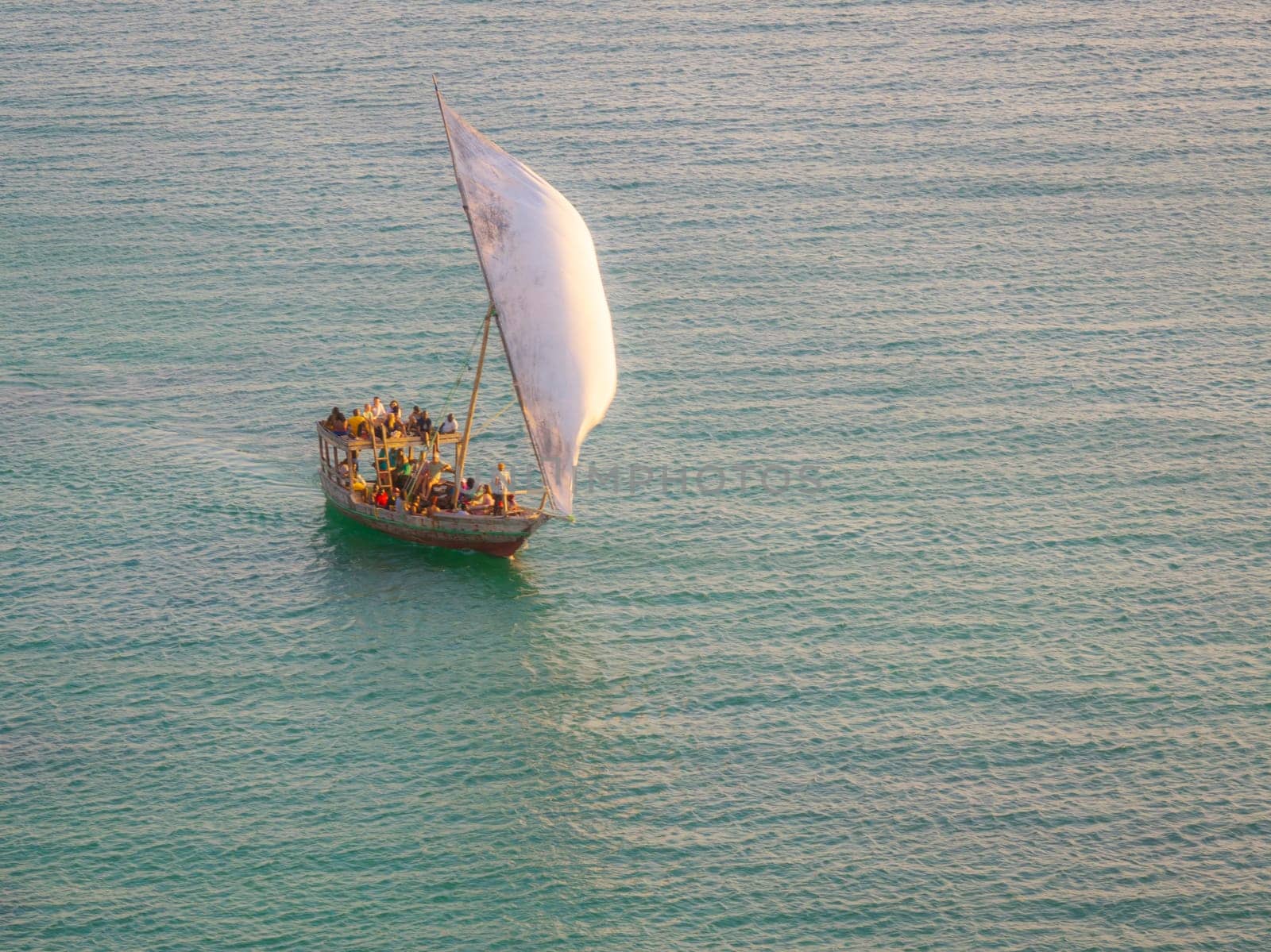 Dhow boat sails in the ocean at sunset by Robertobinetti70