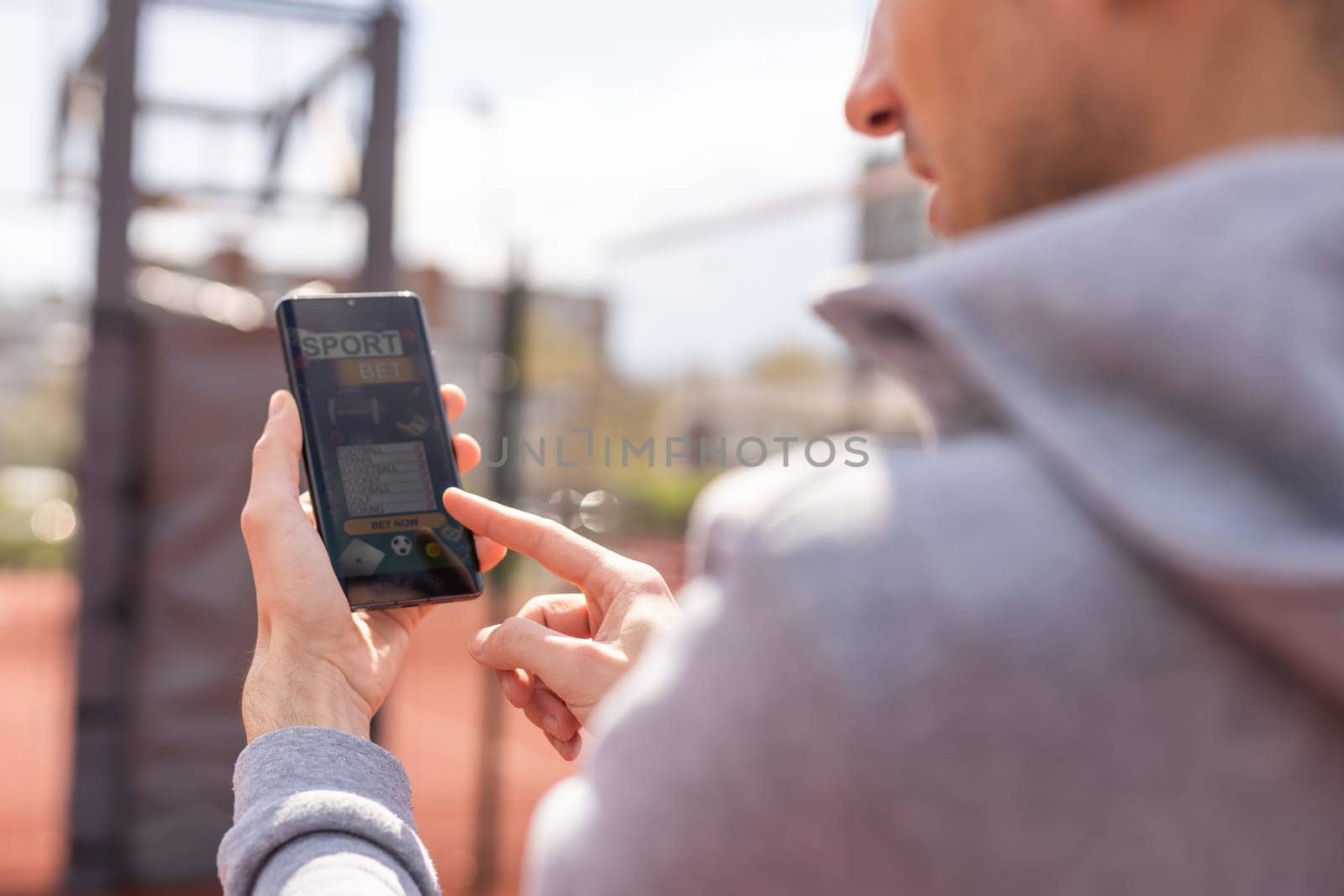 Man using online sports betting services on phone.