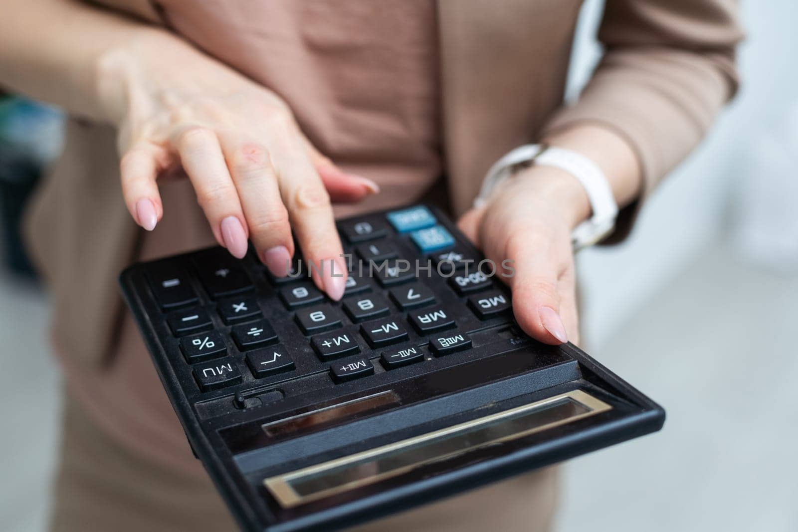 Hand holding the calculator isolated over white background. High quality photo