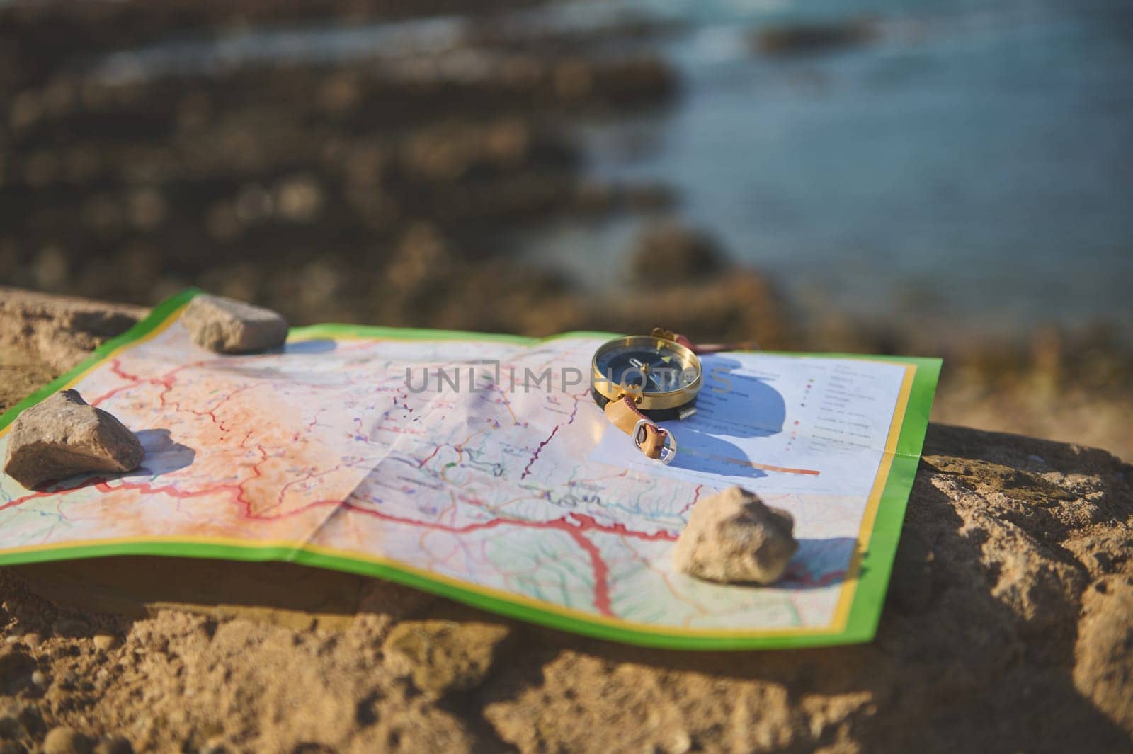 Still life with geographic map and old golden compass with a magnetic arrow showing the north direction during travel. Trip. Tourism. Travel concept. Discovering new travel destinations