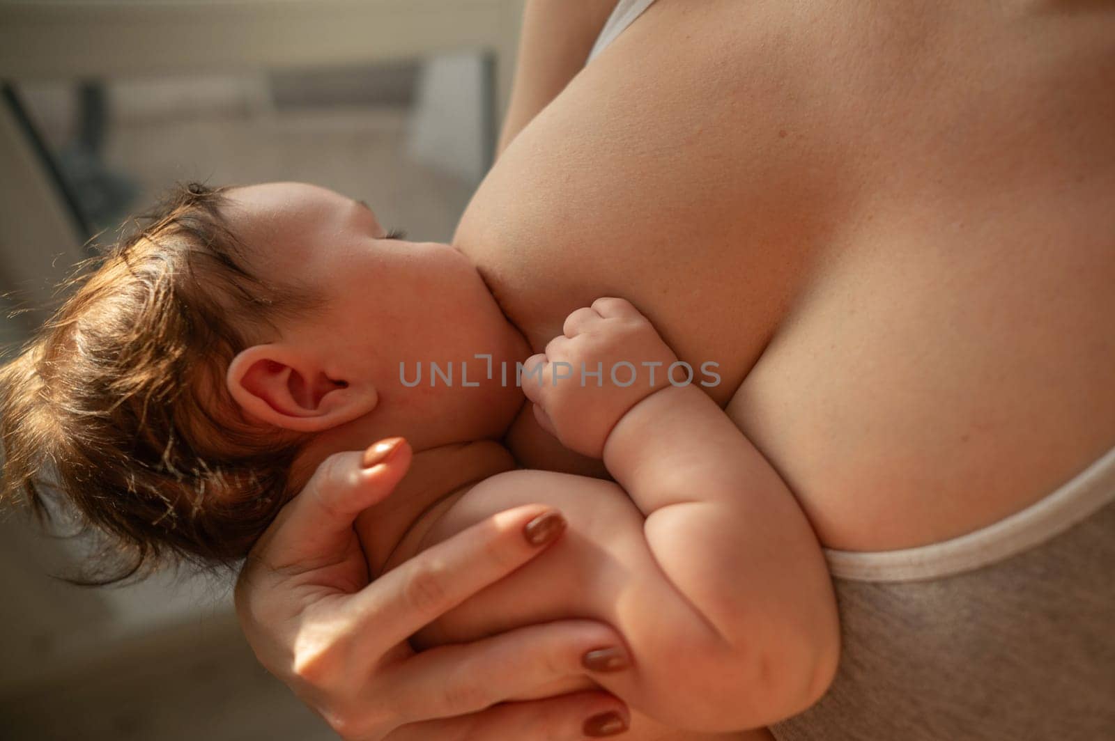 Caucasian woman breastfeeds her four-month-old son