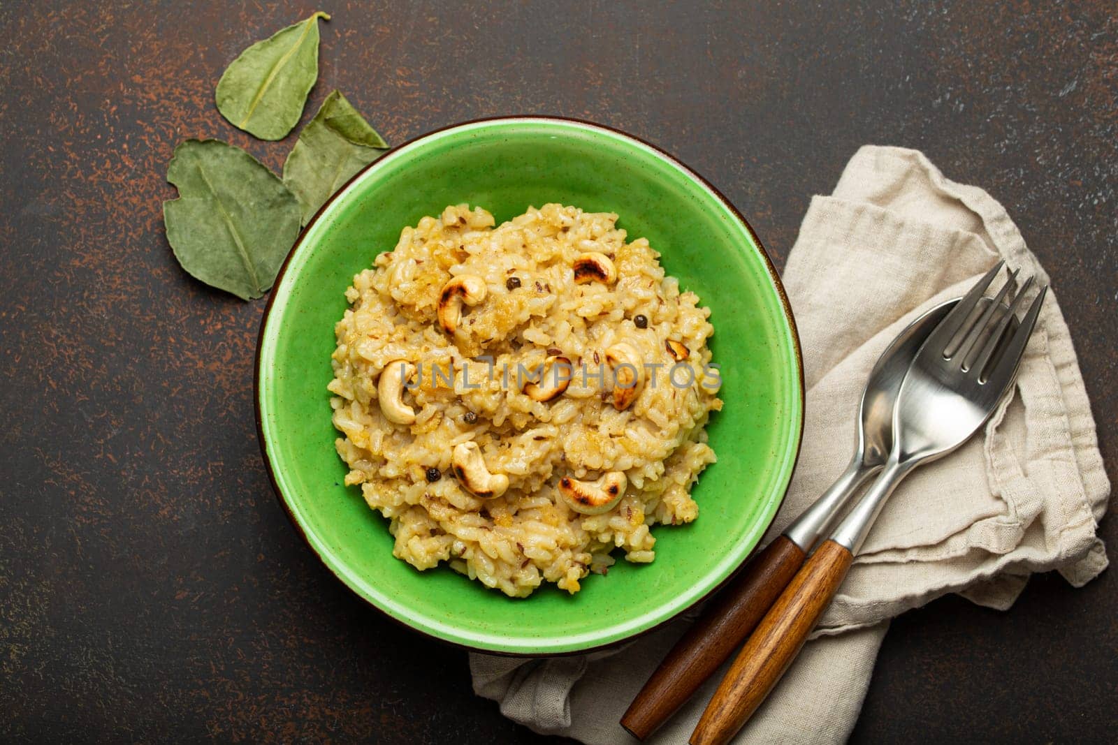 Ven Pongal (Khara Pongal), traditional Indian savoury rice dish made during celebrating Pongal festival, served in bowl top view on concrete rustic background.