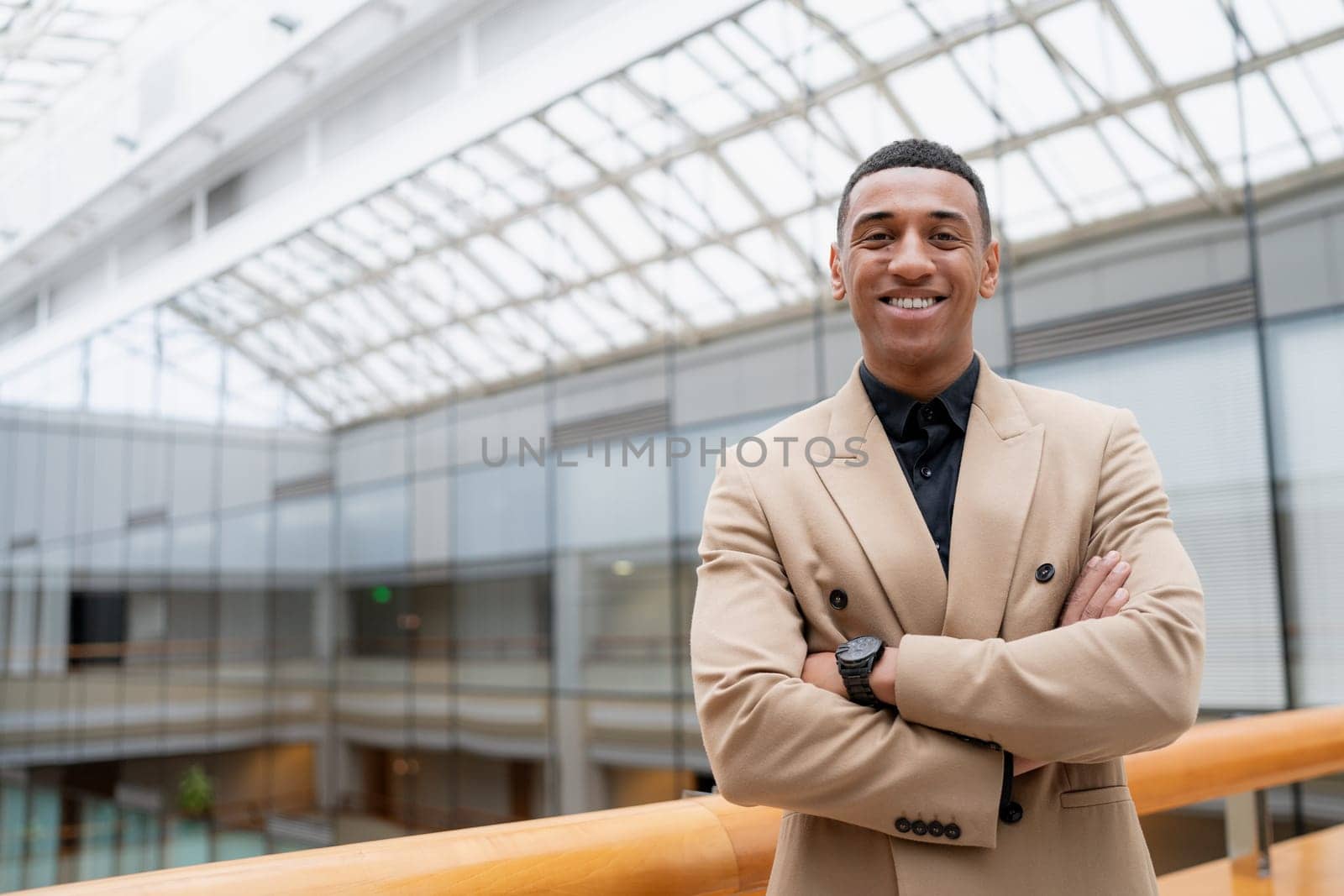Businessman looking at the camera while standing alone in a modern workplace. High quality photo