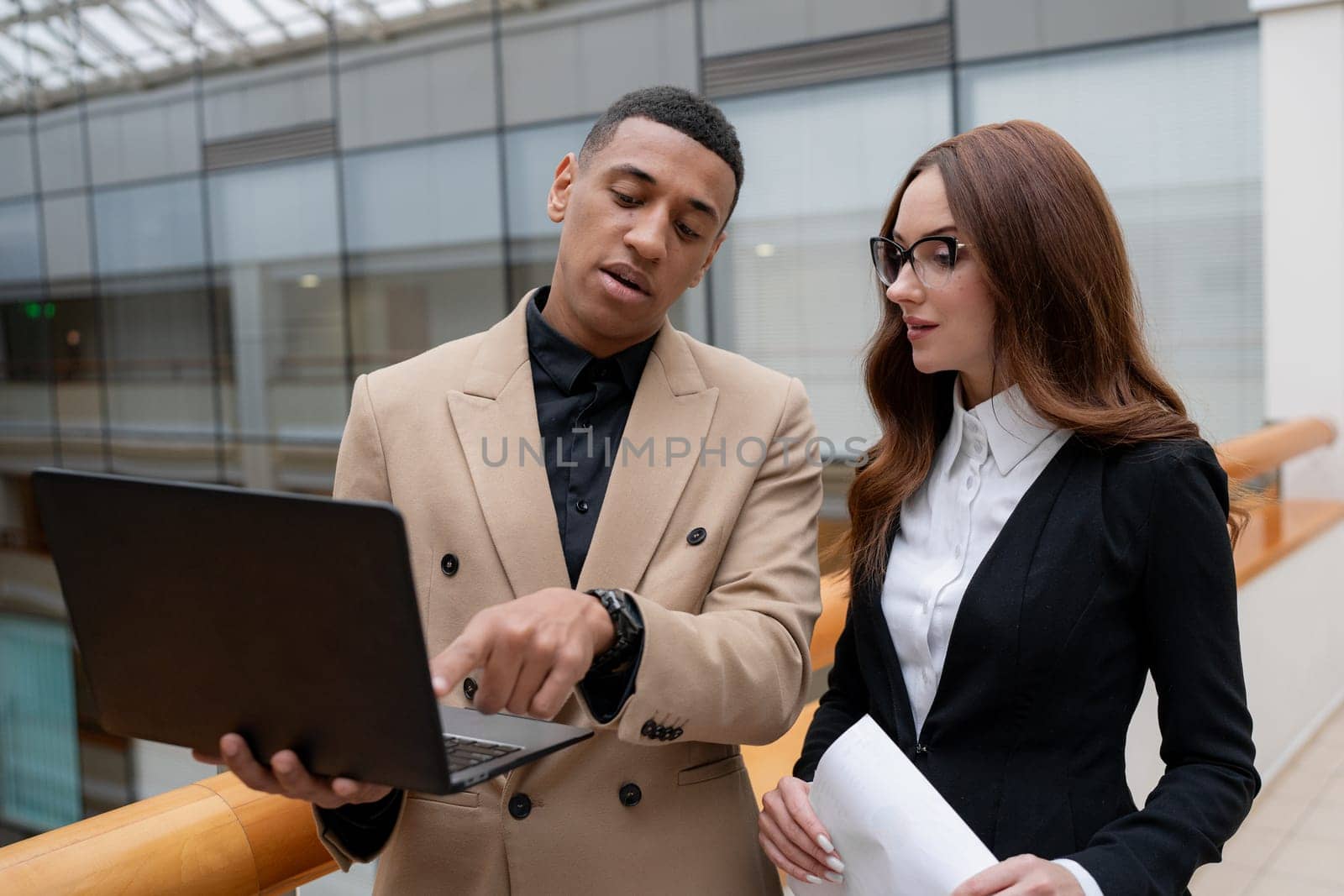 Happy young entrepreneurs smiling while working together in a modern workspace. High quality photo