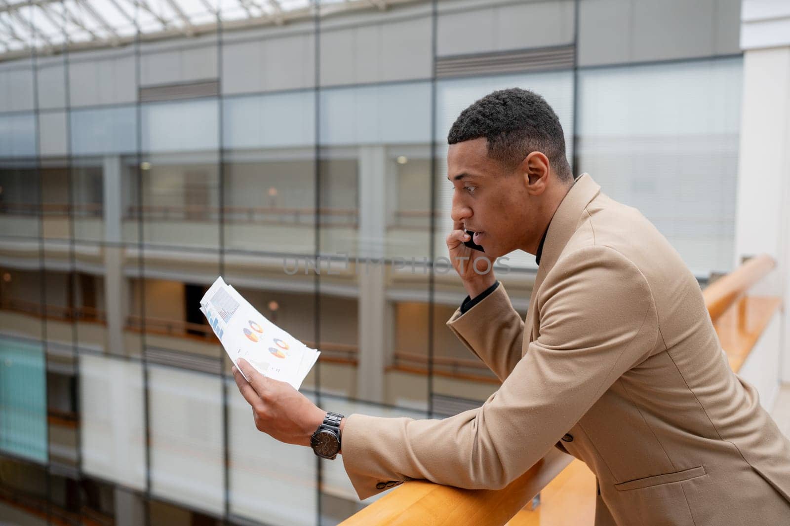 Businessman looking at the camera while standing alone in a modern workplace. High quality photo