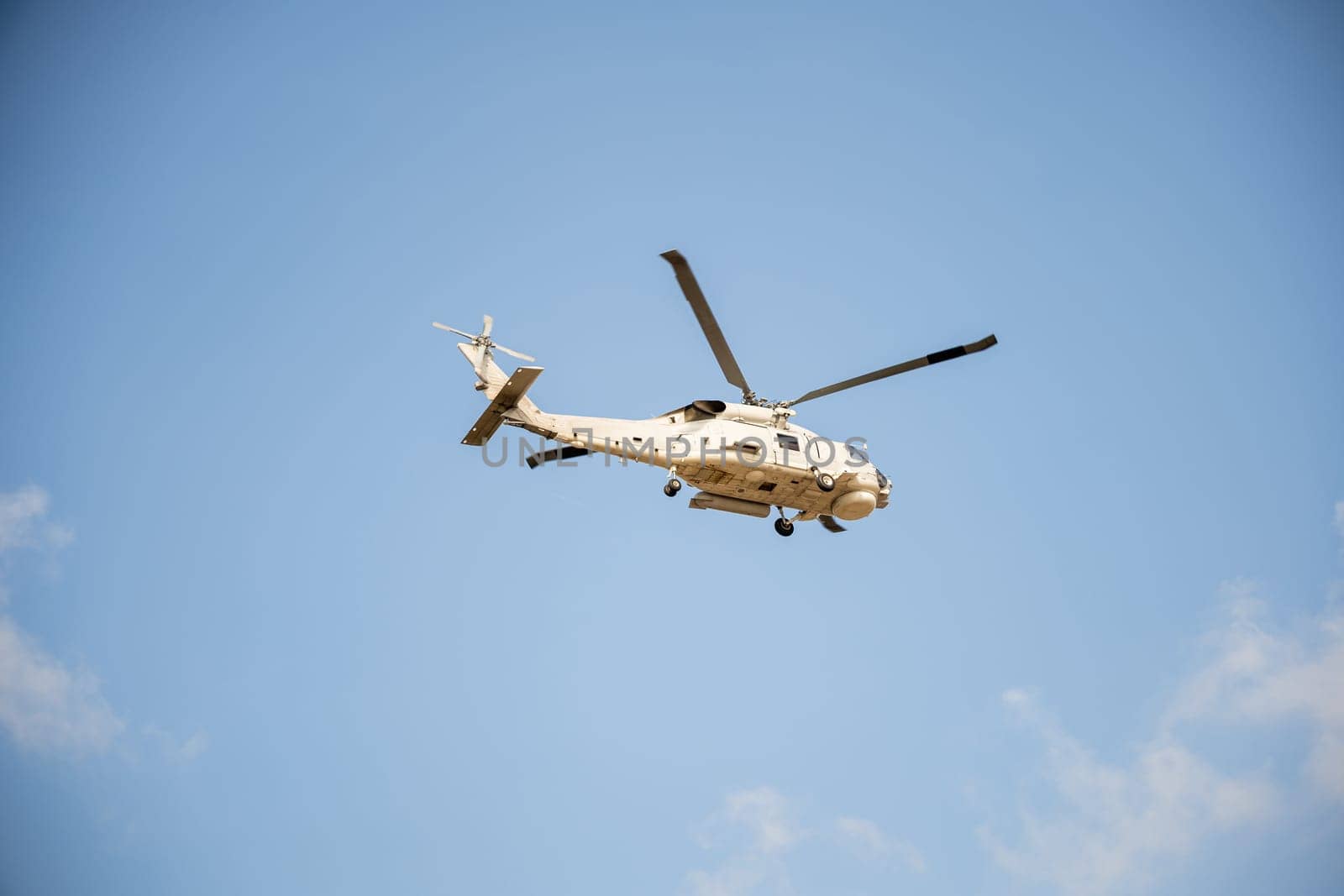 Helicopter in flight against blue sky showcasing modern rescue and transportation technology. New engine hovering capabilities. Pilot manages small aircraft's speed and angles.