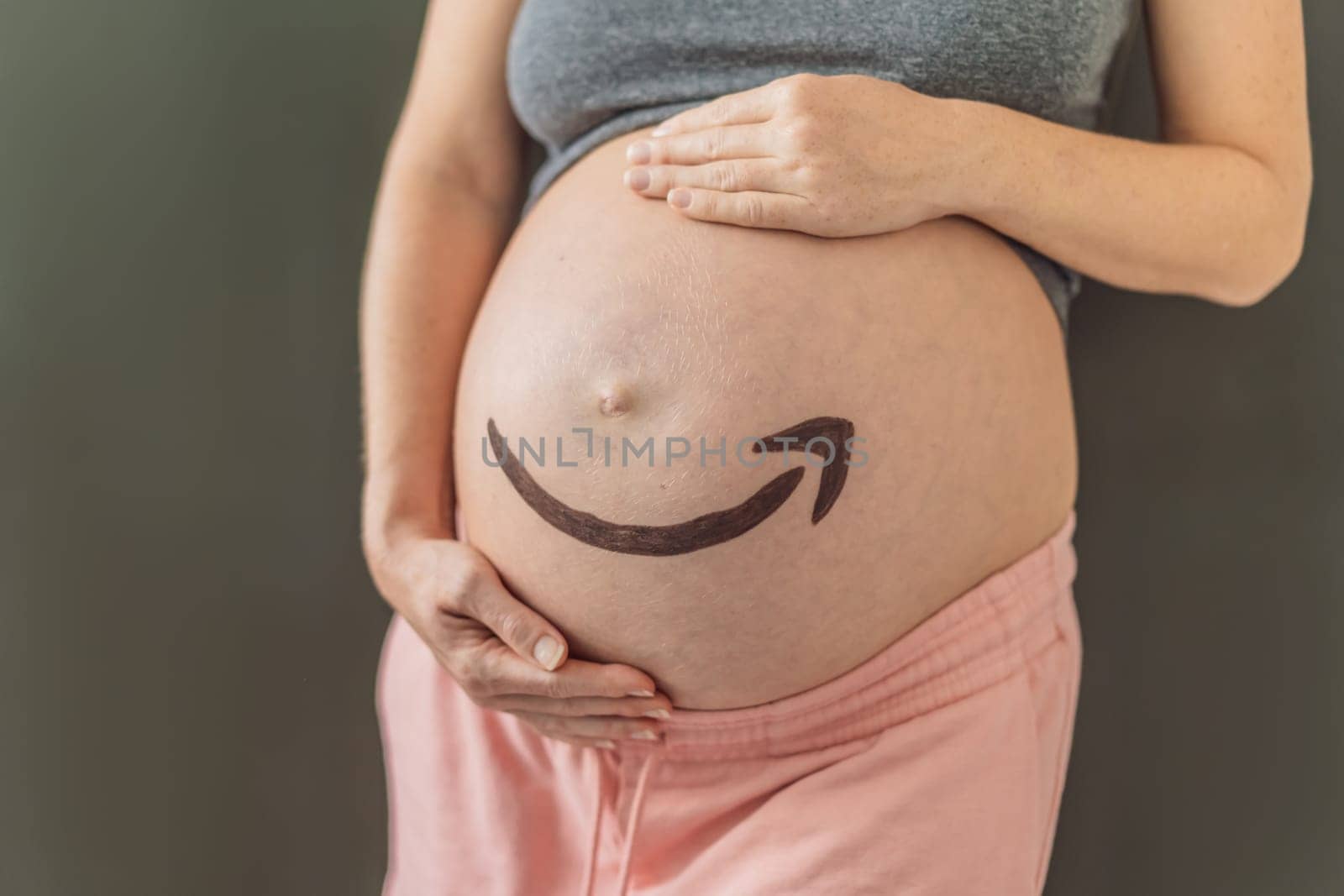 28.01.23, Mexico, Playa del Carmen: Creative concept of an Amazon icon on a pregnant belly, symbolizing the anticipation and delivery of joy, much like the reliable and timely services provided by Amazon. As well as products for pregnant women and babies on Amazon.