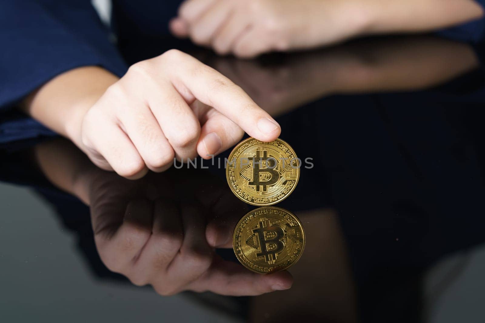 Close-up of finger touching golden bitcoin coin. Cryptocurrency and future money concept