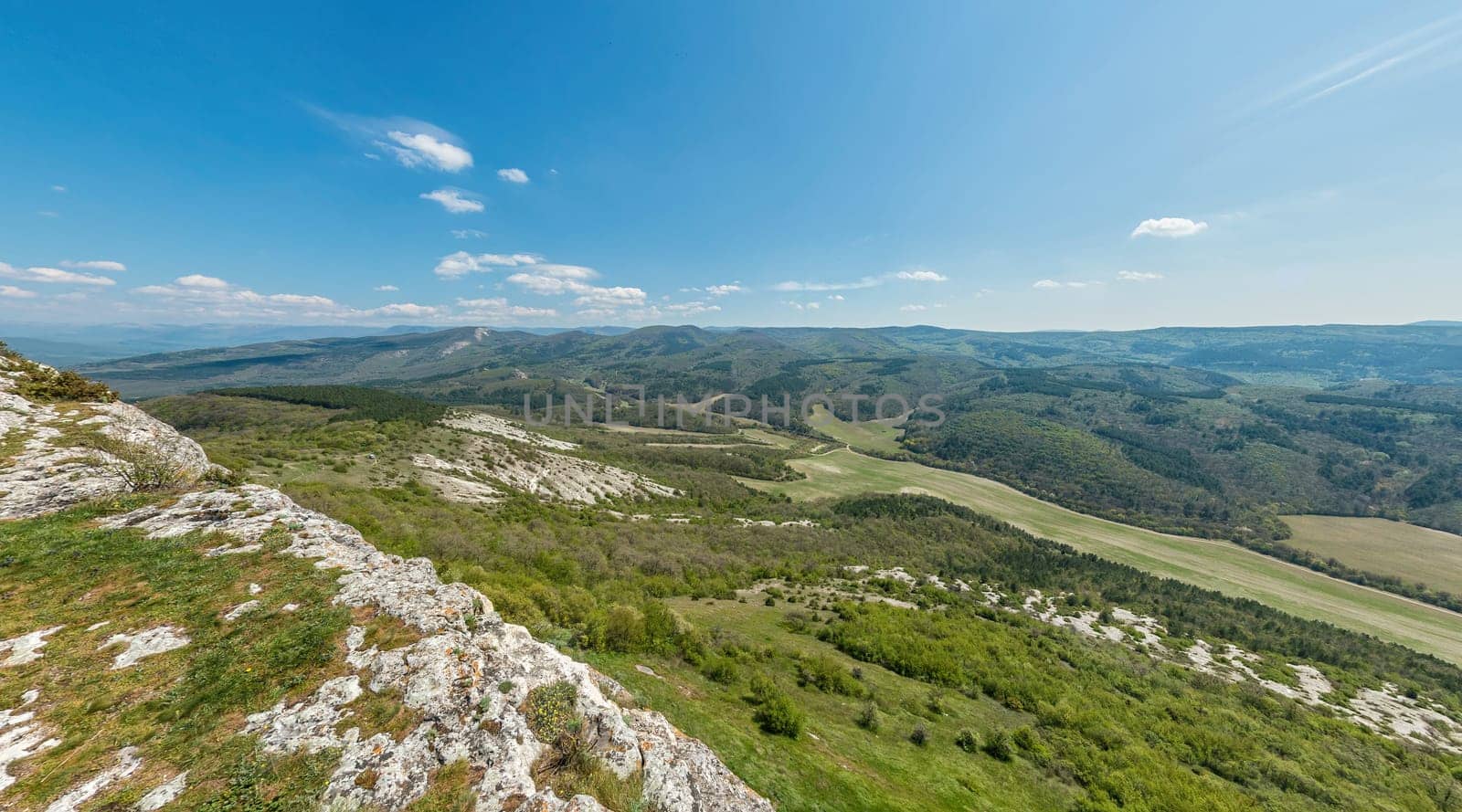 Wide panoramic view on mountain landscape with lush green hills under clear blue sky, tranquil natural beauty, perfect for outdoor enthusiasts. by panophotograph
