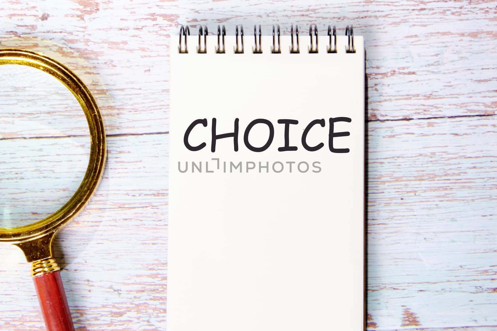 CHOICE a word written on a notebook on wooden boards next to a magnifying glass by Ihar