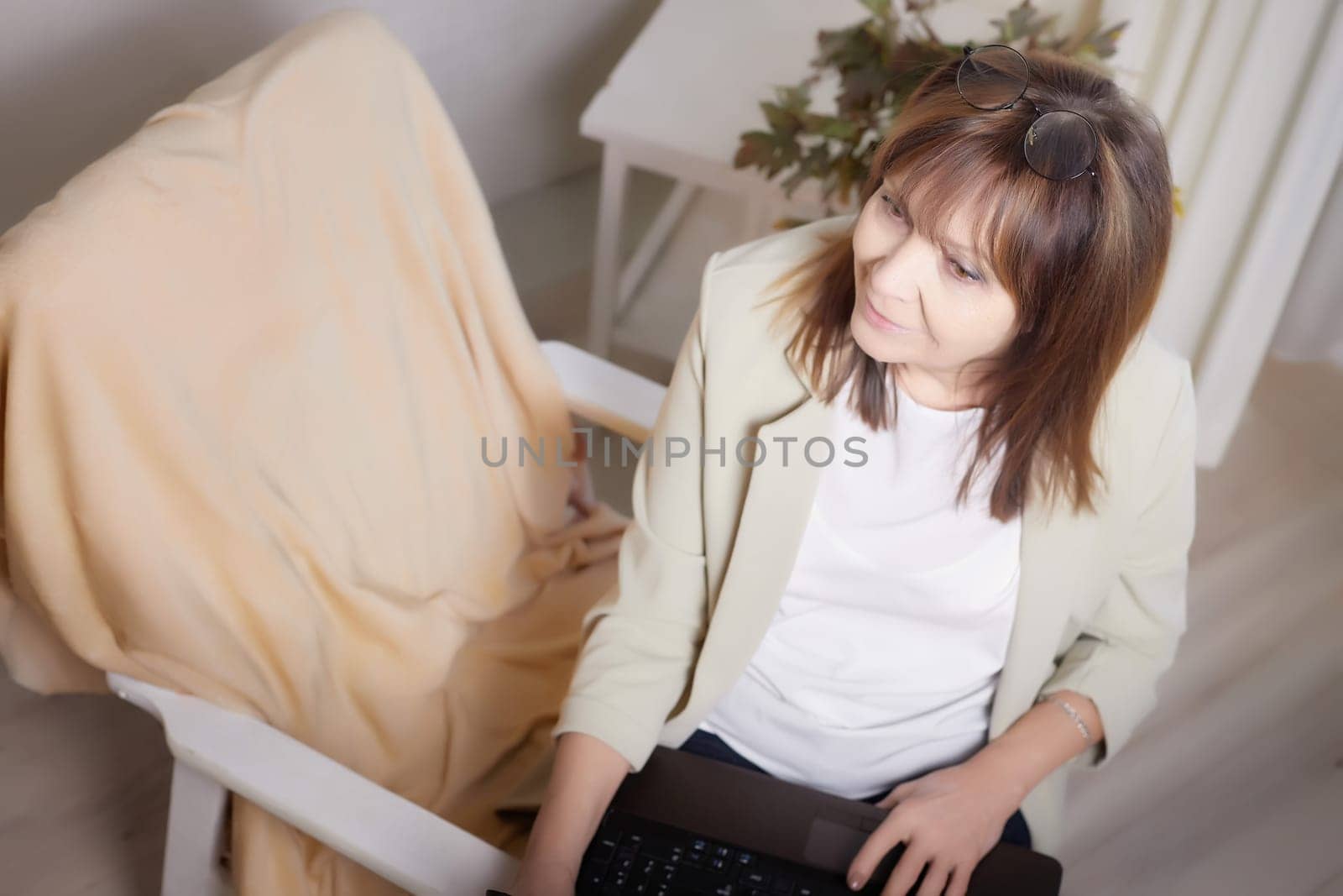 Elderly lady with glasses and laptop in room. Businesswoman is leader, manager working online. Blogger streaming. Grandma with family on Internet