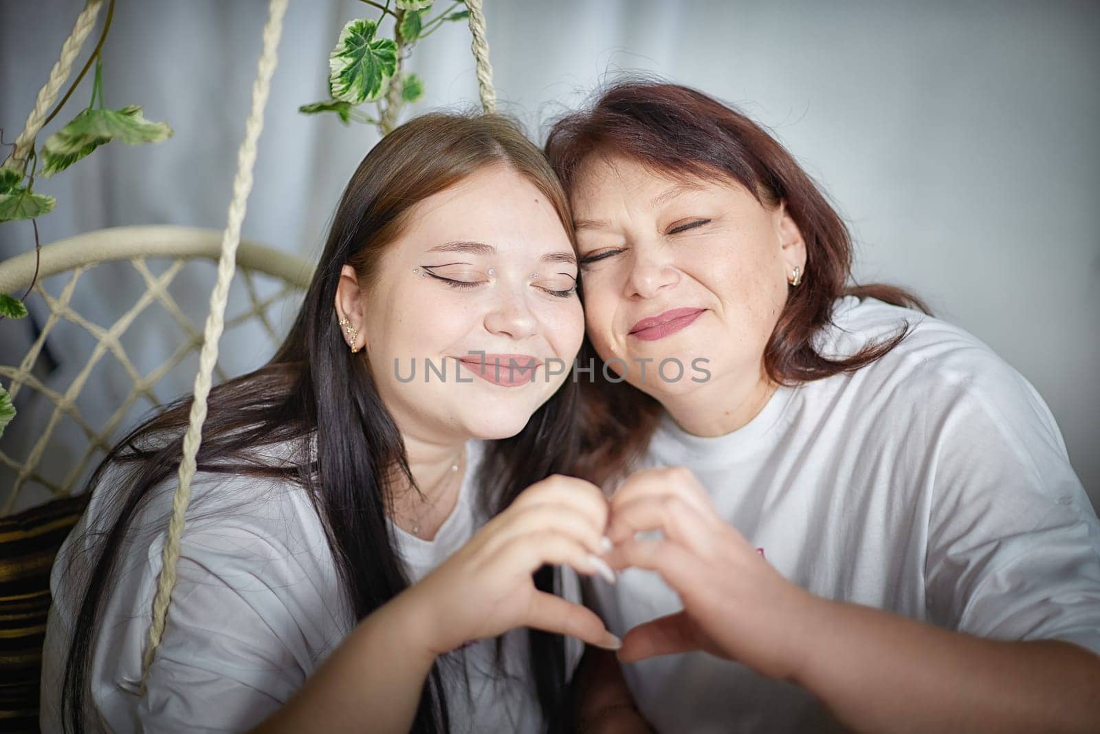 Happy Overweight family with mother and daughter in room. Middle aged woman and teenager girl having fun, joy and hugging
