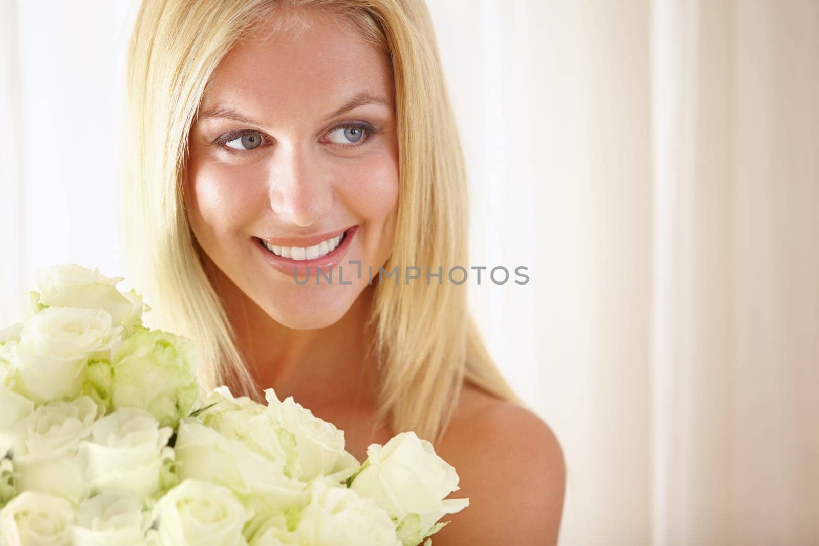 Face, smile or thinking and woman with flowers closeup in her home for romance on valentines day. Beauty, rose bouquet and a happy young blonde woman in her apartment for anniversary celebration.