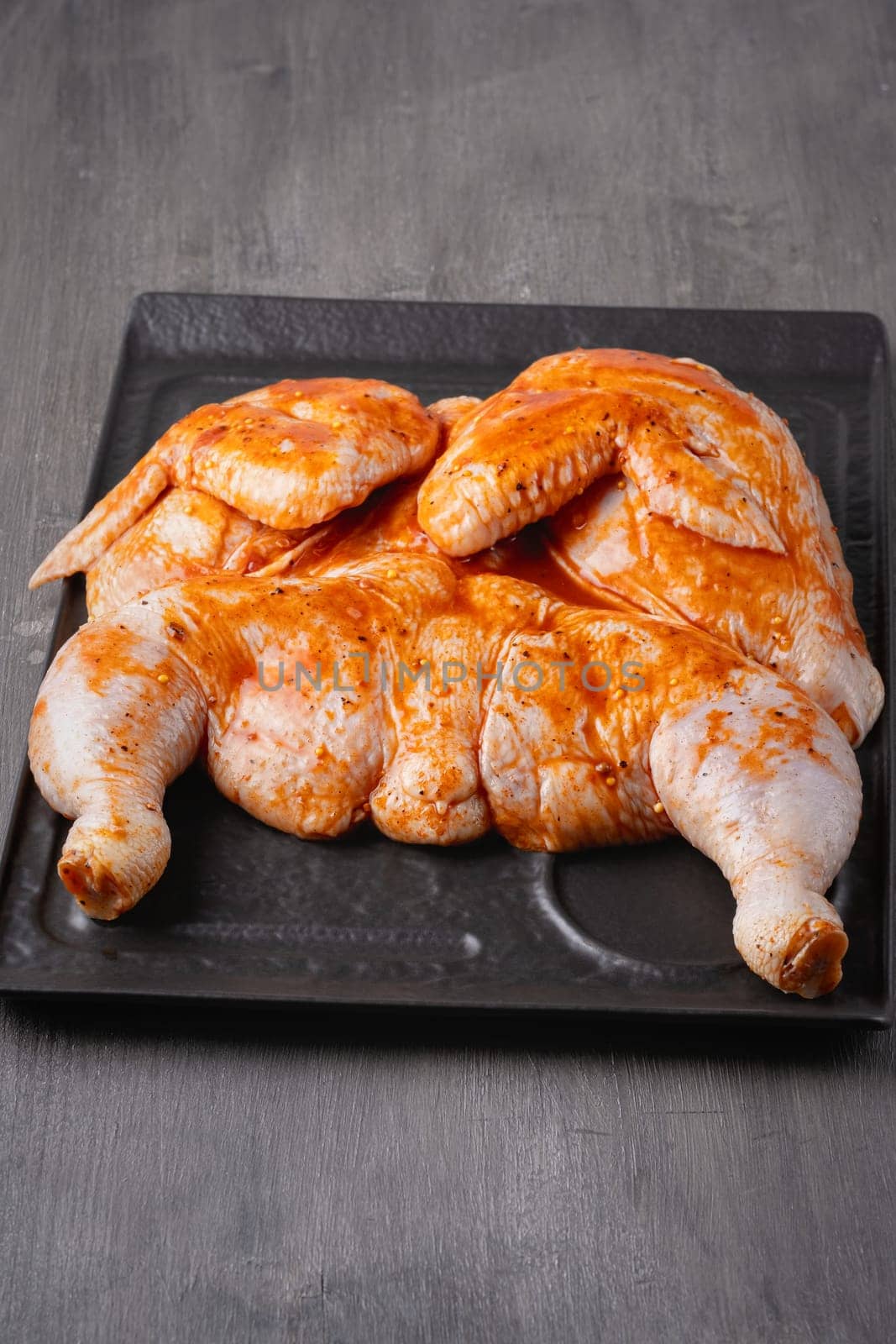 Whole chicken carcass with seasonings on grey background for your meat menu or booklet design.