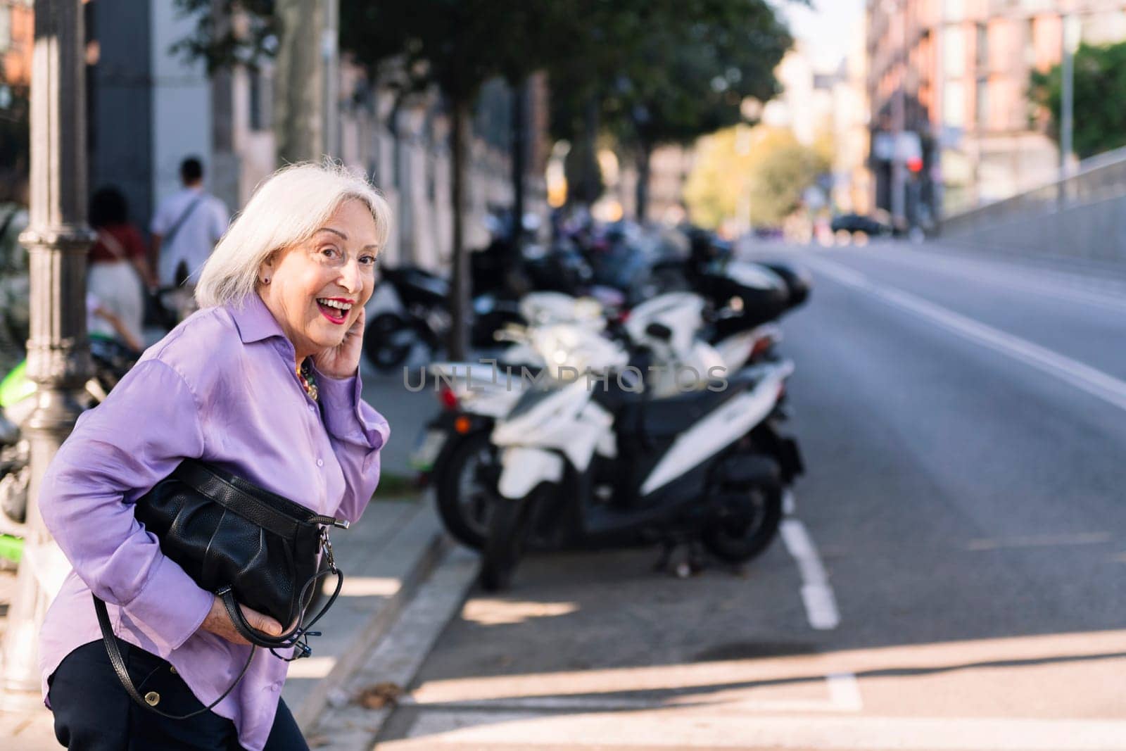 happy smiling senior woman looking before crossing a city street, concept of elderly people leisure and active lifestyle, copy space for text