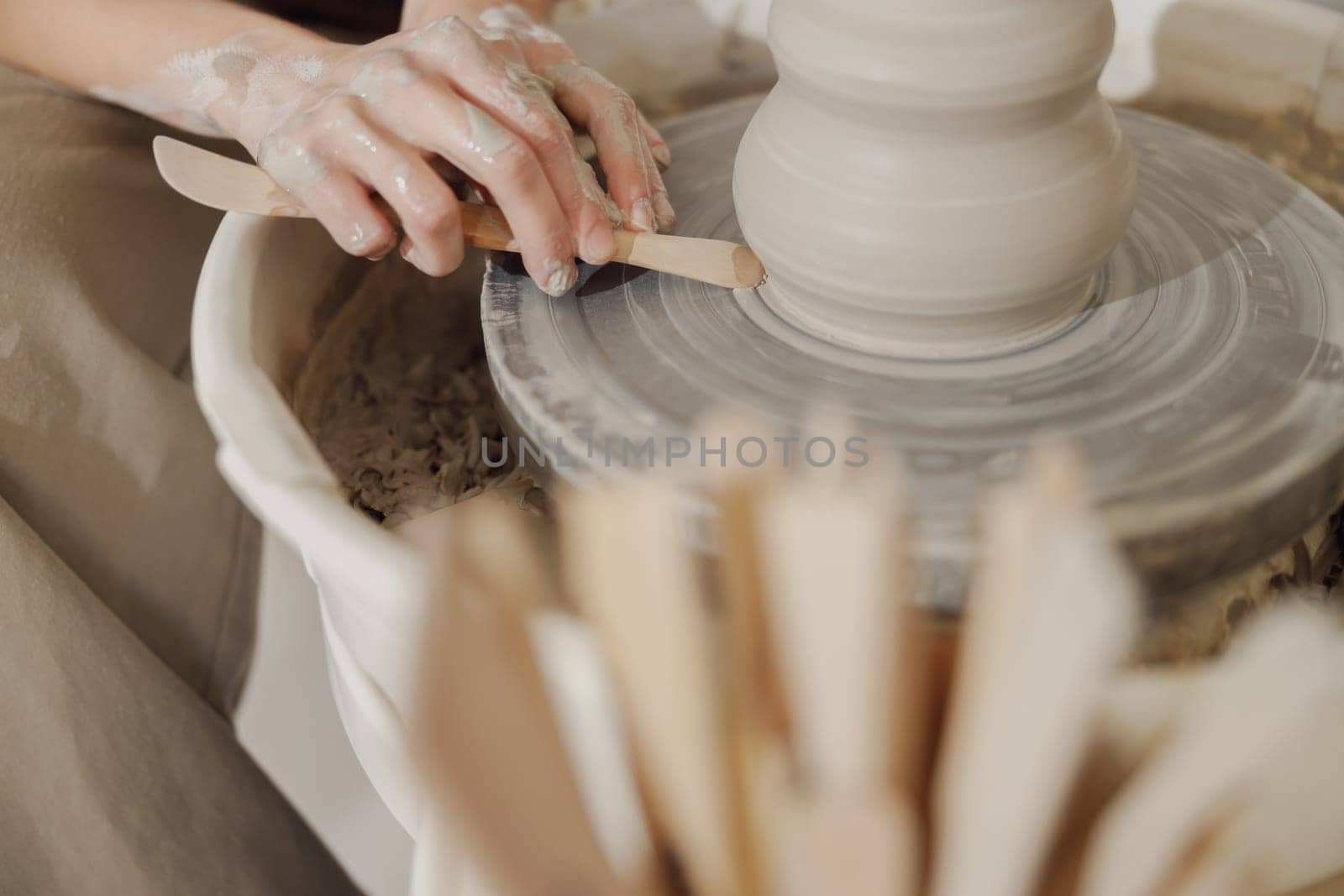 Close up of artisan's hands shaping clay bowl in pottery studio. Pottery art and creativity by Yaroslav_astakhov