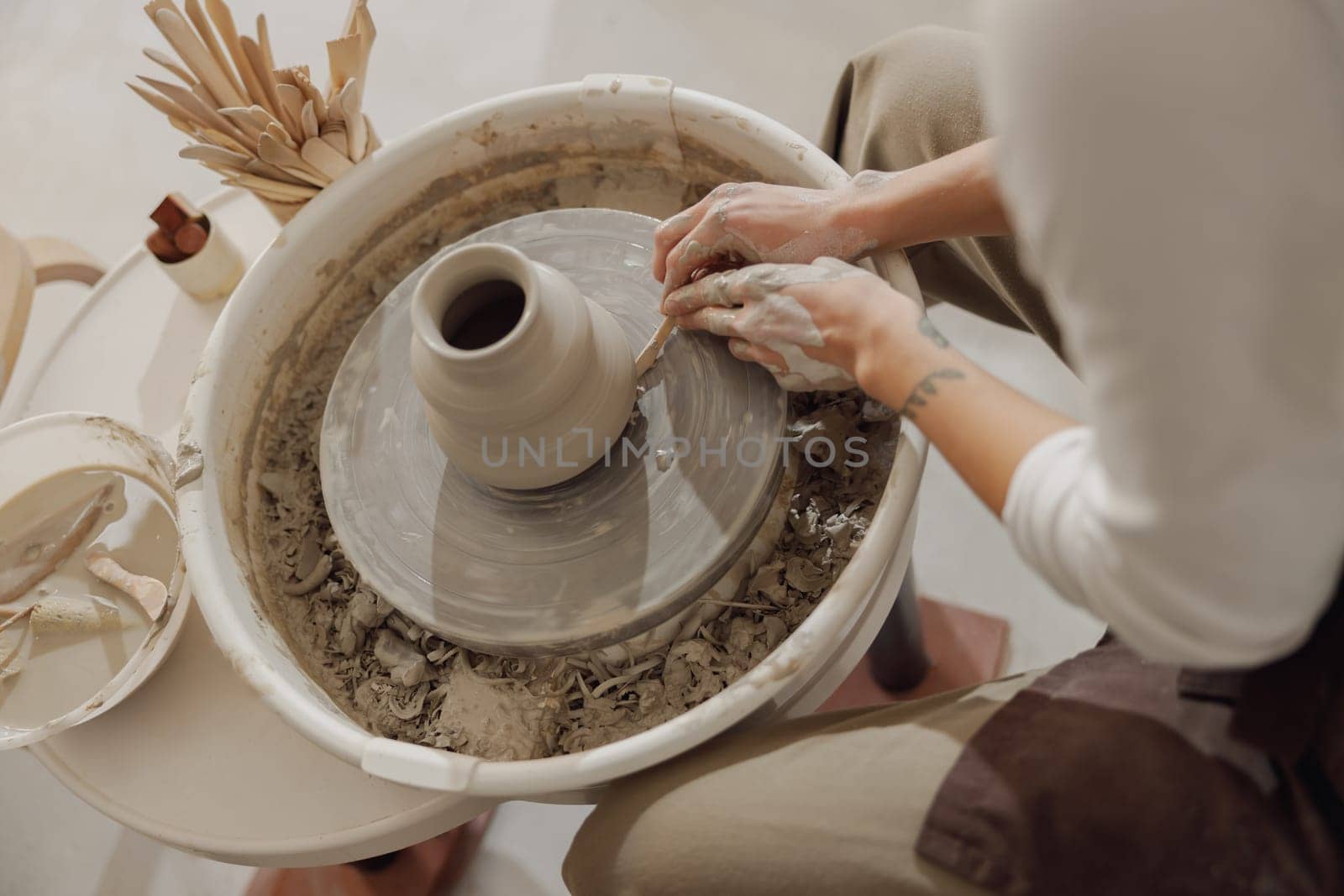 Close up of artisan's hands shaping clay bowl in pottery studio. Pottery art and creativity by Yaroslav_astakhov