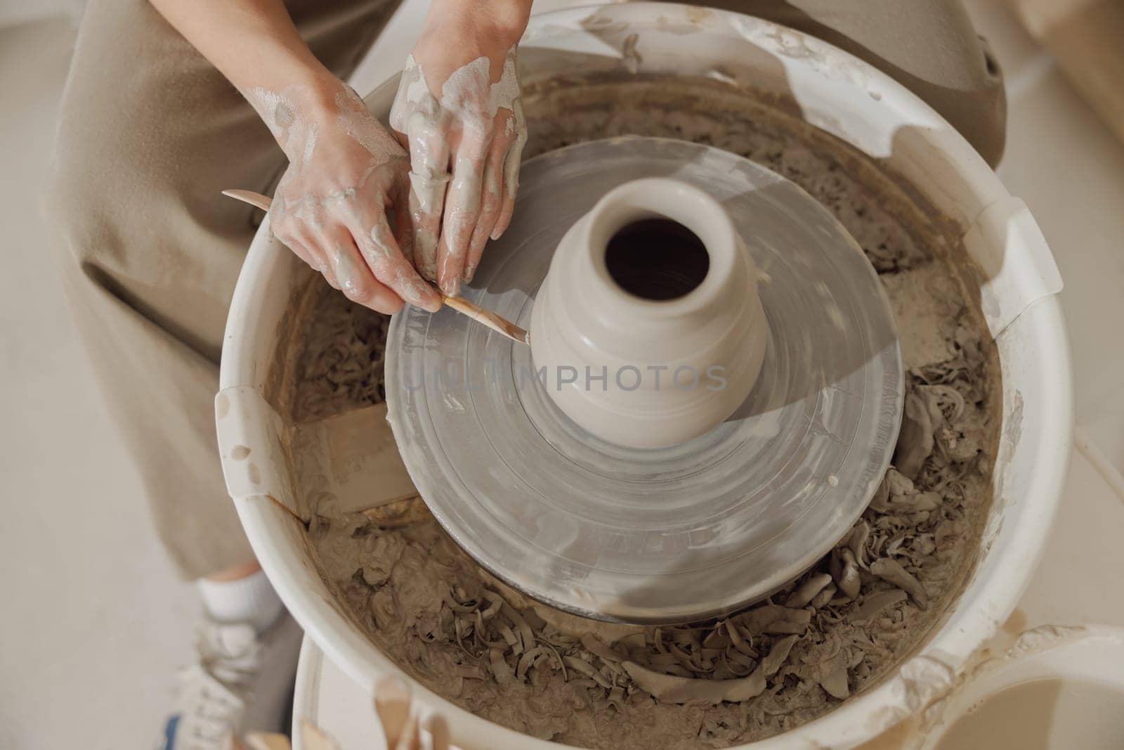 Close up of artisan's hands shaping clay bowl in pottery studio. Pottery art and creativity by Yaroslav_astakhov