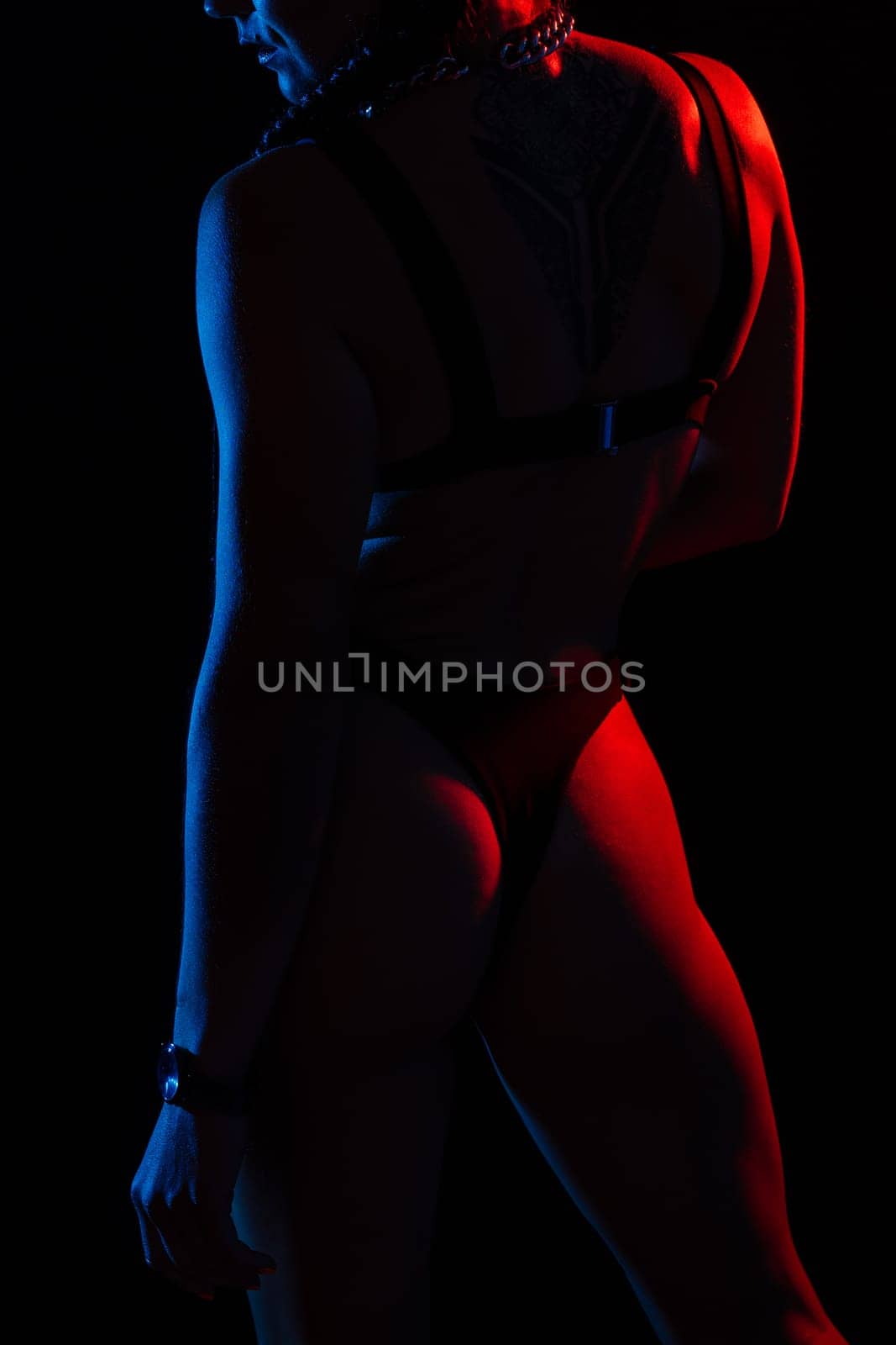 Young woman in underwear is in a studio with neon lights.