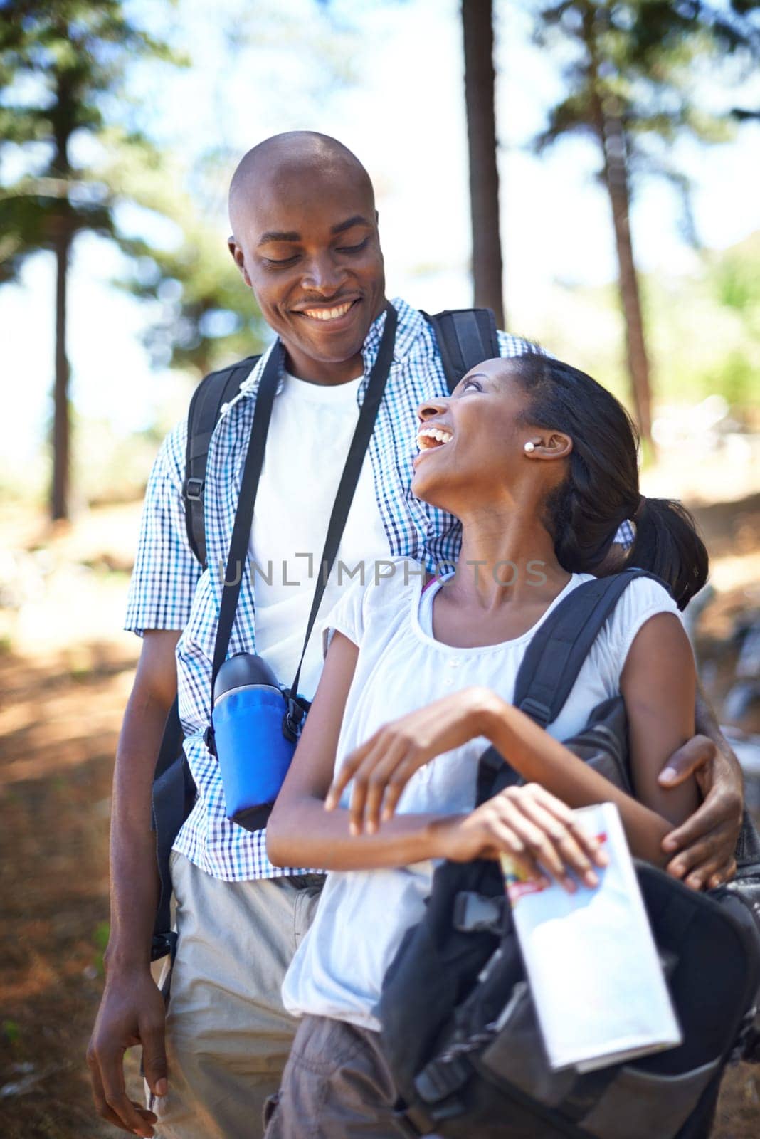 Happy black couple, hiking and bonding in forest for outdoor adventure, travel or holiday together in nature. African man and woman smile in woods enjoying fresh air, trip or trekking for weekend.