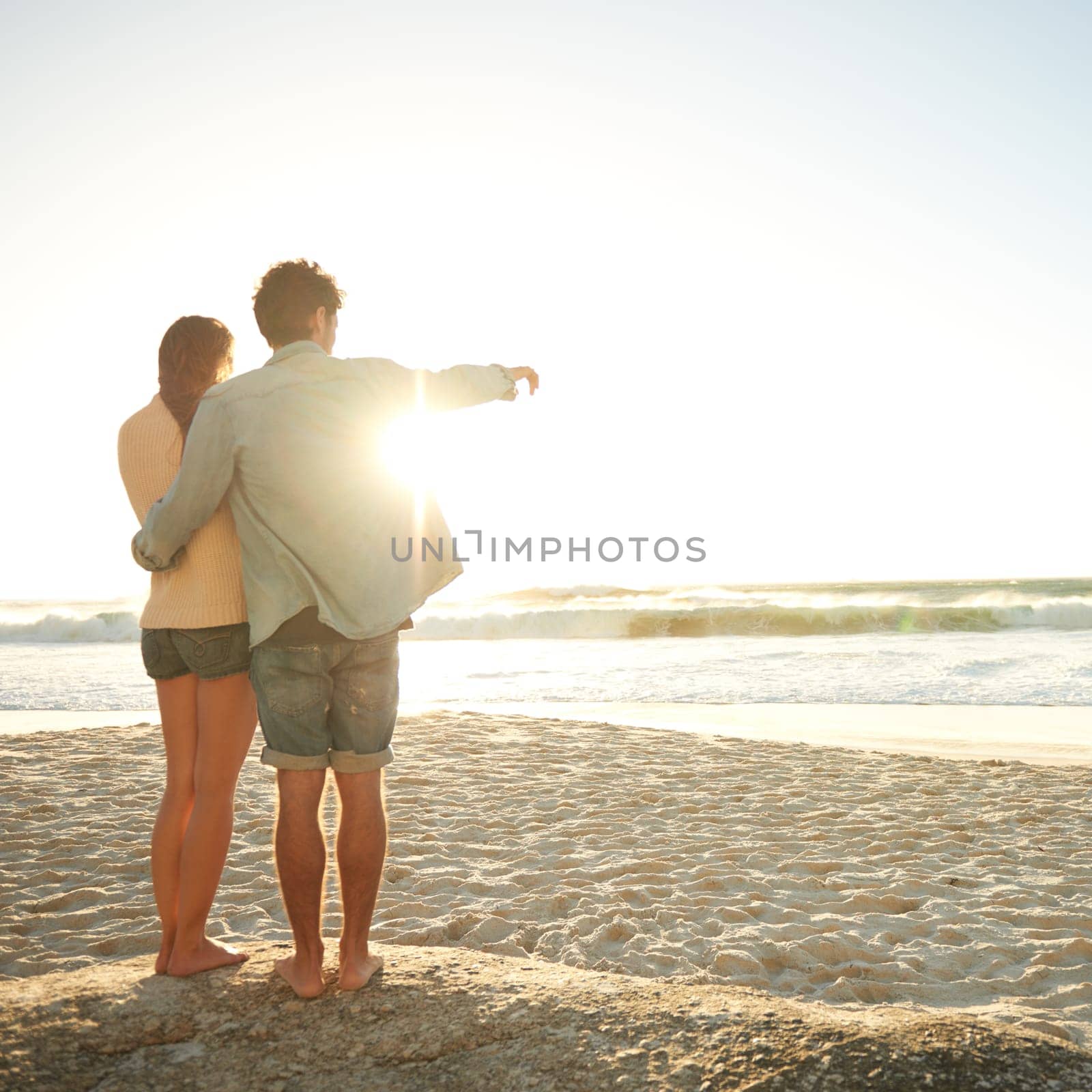 Beach sunset, hand pointing or couple in nature with hug, support or love. Summer, romance or back of people at sunrise with ocean view, conversation or adventure on vacation, holiday or Florida trip.